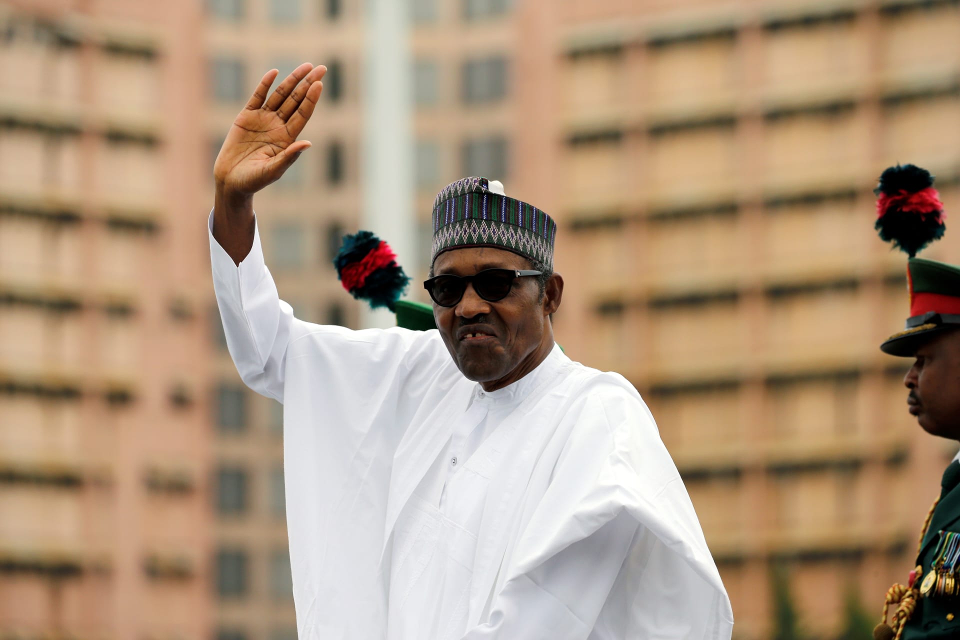<p>Nigerian President Muhammadu Buhari waves at the crowd while he drives around the venue during his inauguration for a second term in Abuja, Nigeria, on May 29, 2019.</p>
