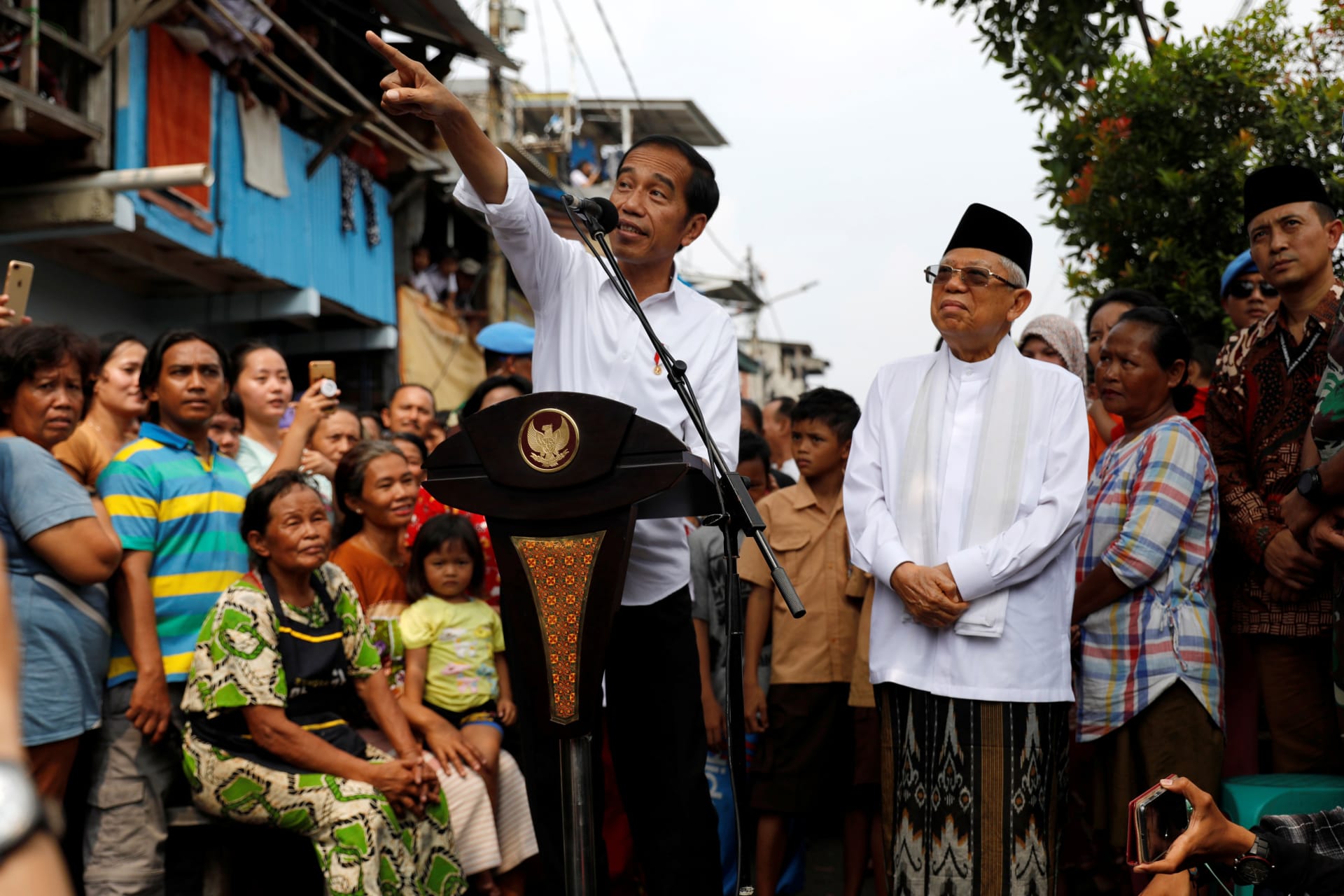 <p>Indonesia’s Incumbent President Joko Widodo gestures next to his running mate Ma’ruf Amin as they make a public address following the announcement of the last month’s presidential election results at a rural area of Jakarta, Indonesia, on May 21, 2019.</p>
