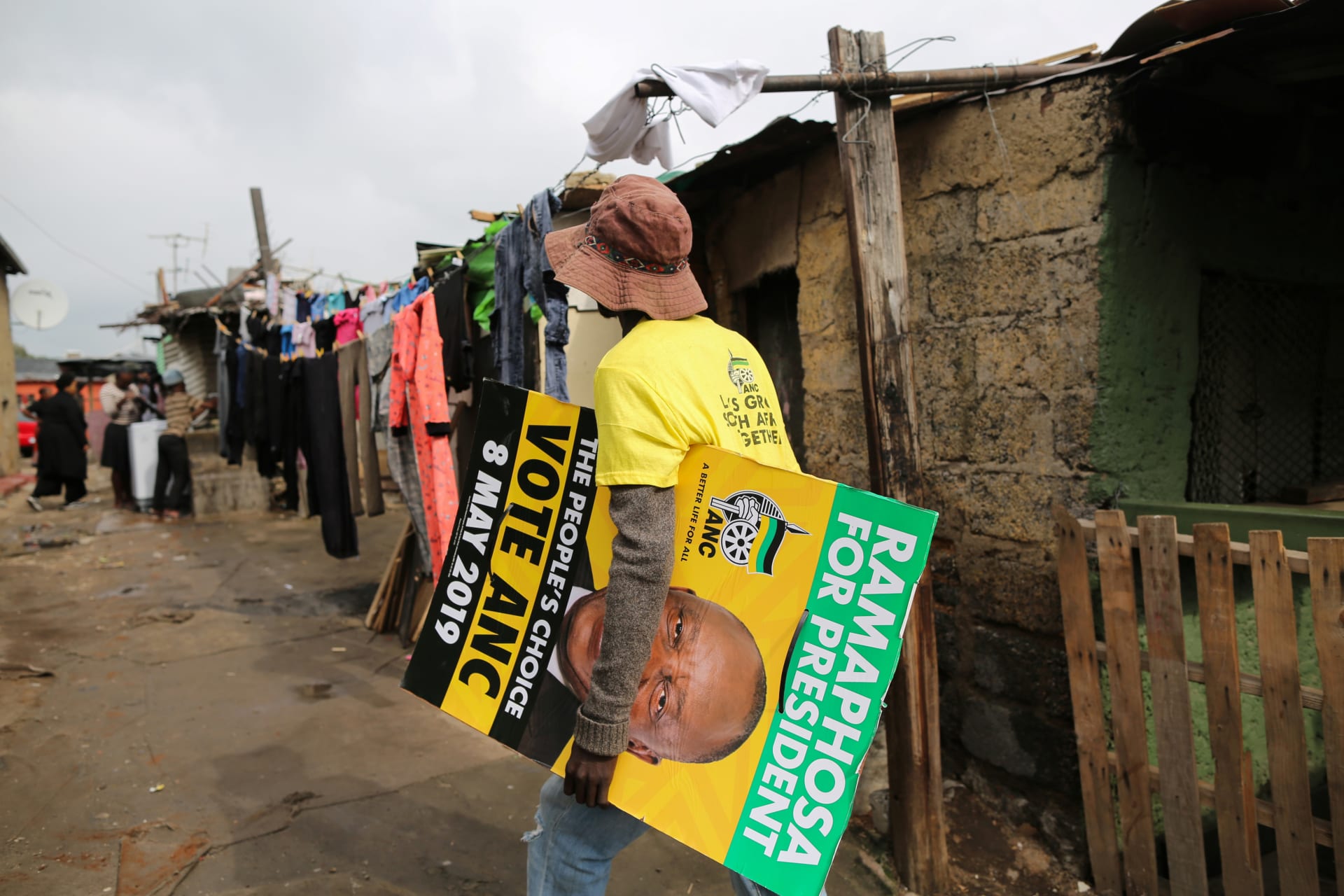<p>A man carries an election poster of the ruling African National Congress (ANC) through Alexandra township in Johannesburg, South Africa, on April 11, 2019.</p>
