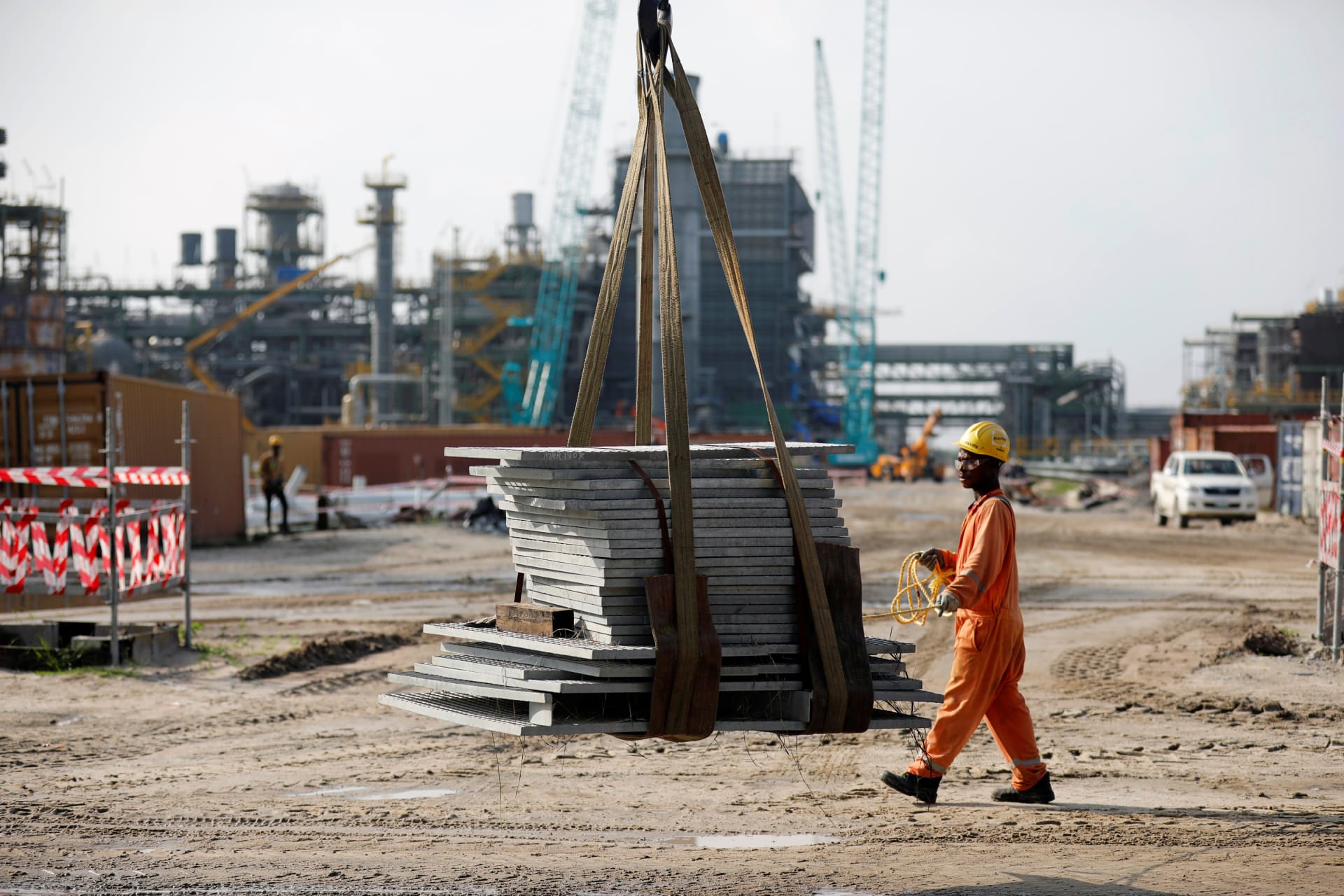 <p>A construction worker assists with moving building materials on a lift at the Dangote Oil Refinery under construction, in Ibeju Lekki district, on the outskirts of Lagos, Nigeria, on July 5, 2018. </p>
