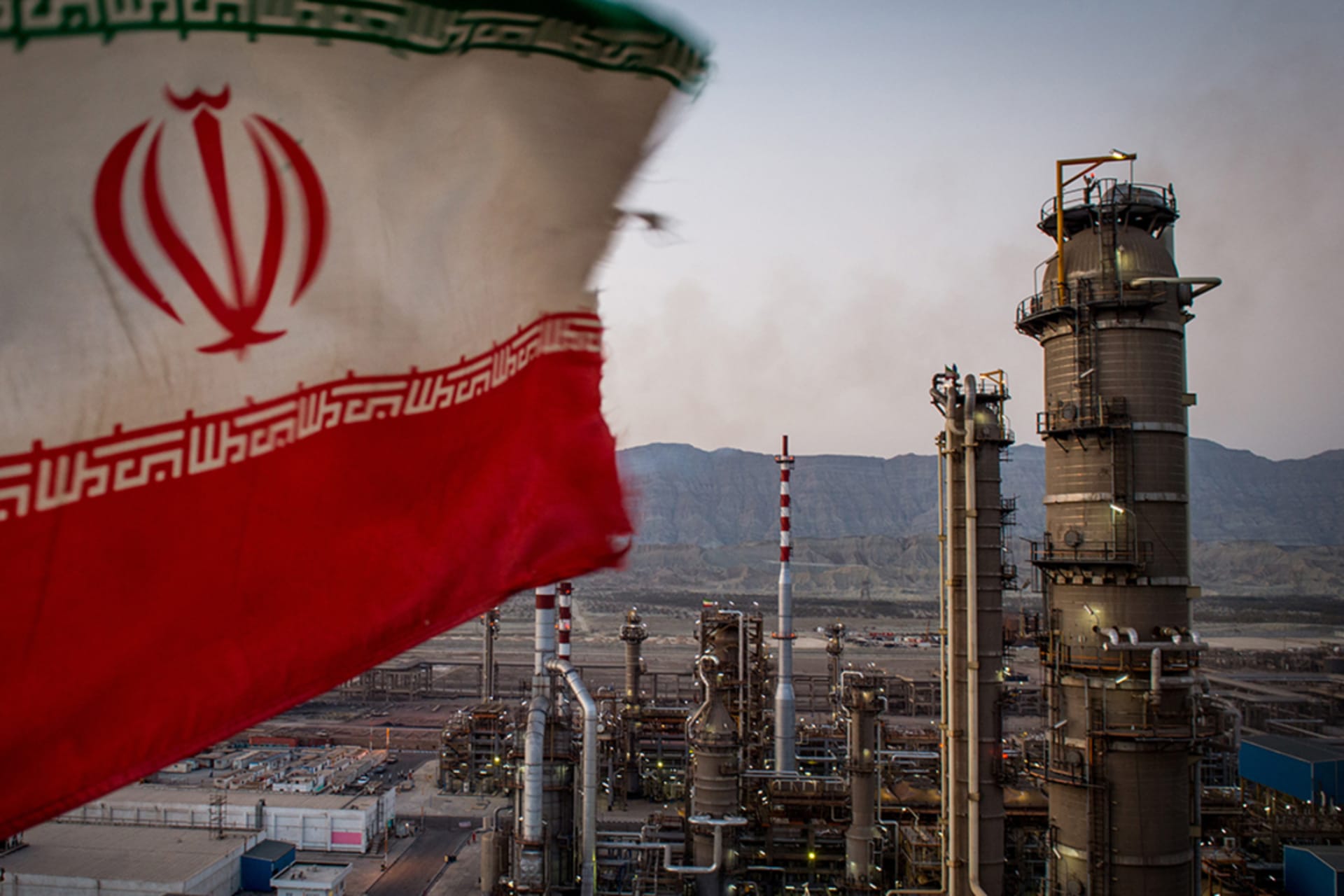 <p>An Iranian national flag flies over a refinery in Bandar Abbas, Iran.</p>
