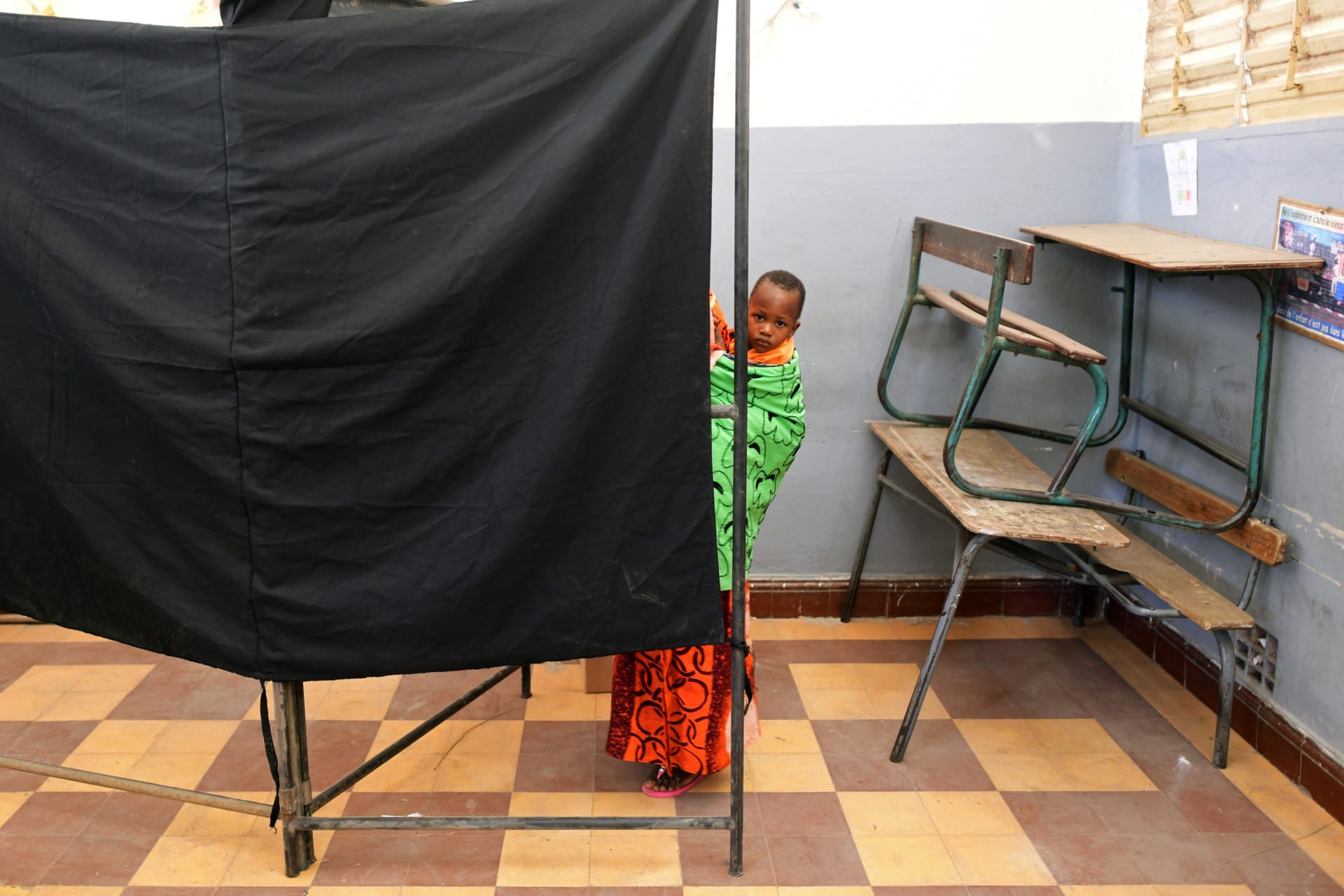 <p>A woman carries a child as she casts her vote during presidential election, at a polling station in Medina neighborhood, in Dakar, Senegal, on February 24, 2019.</p>

