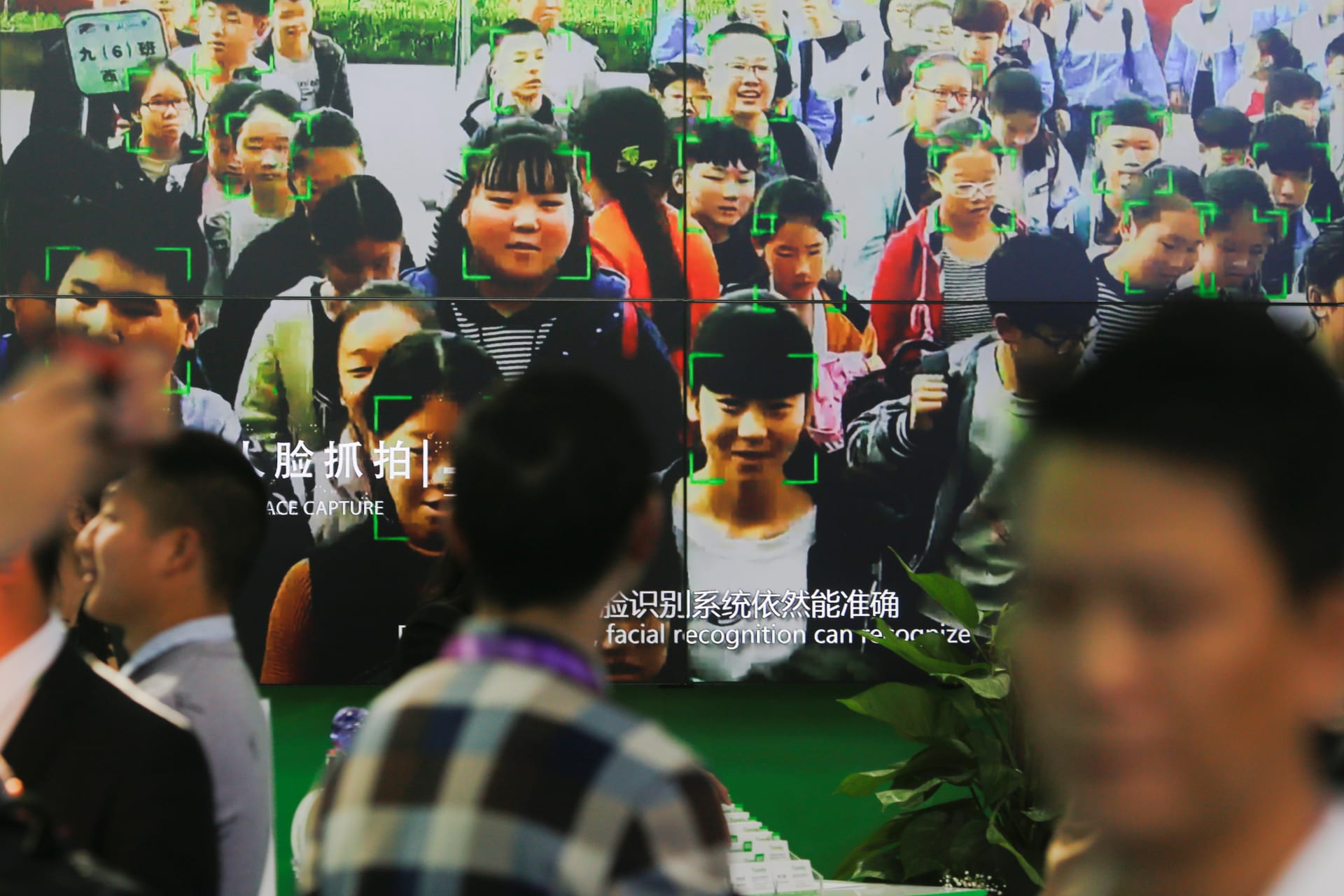 <p>Visitors walk past a screen showing a demonstration of facial recognition software at the Security China 2018 exhibition on public safety and security in Beijing, China October 23, 2018</p>
