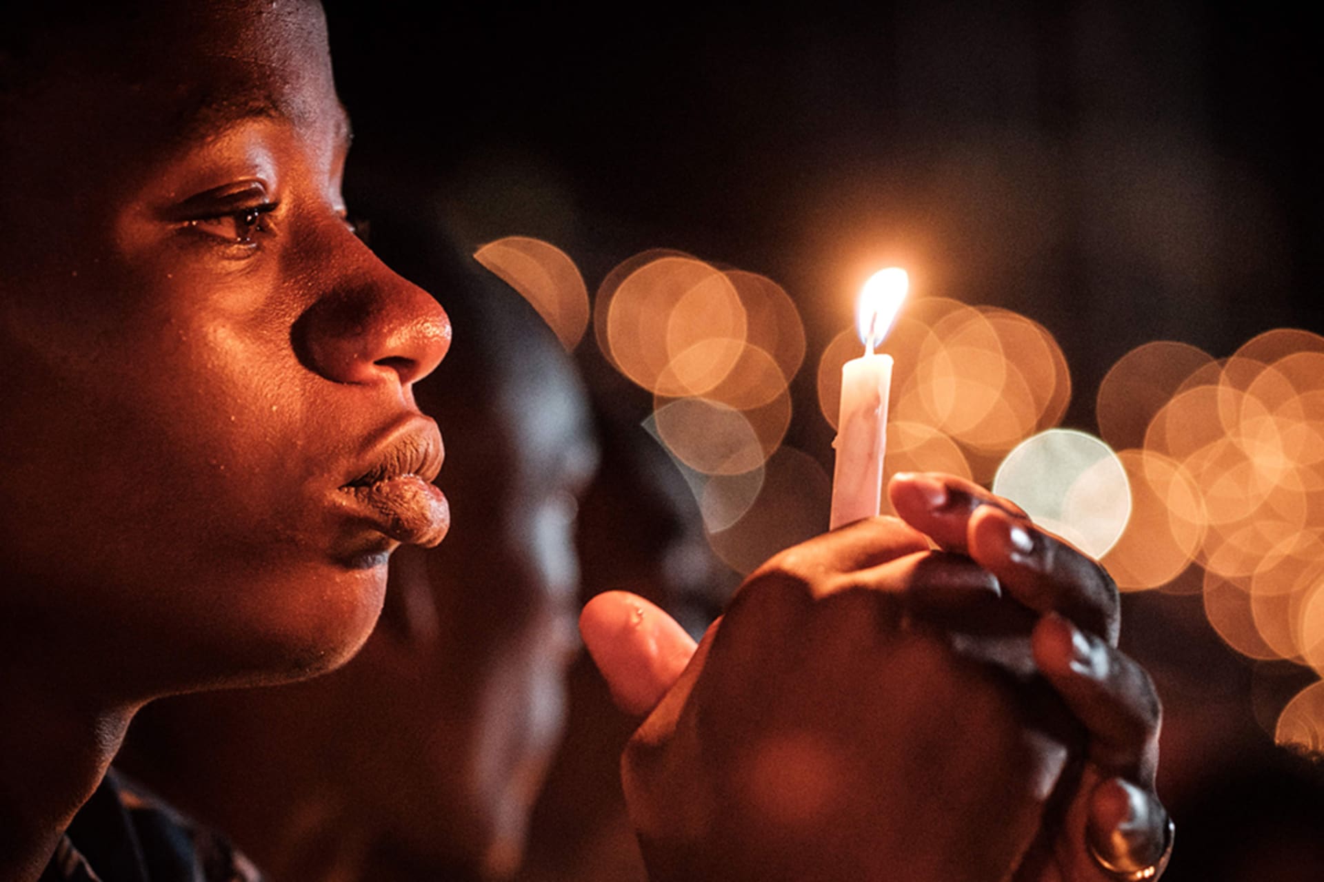 <p>A person holds a candle during a night vigil and prayer at the Amahoro Stadium as part of the 25th commemoration of the 1994 genocide, in Kigali, Rwanda, on April 7, 2019.</p>
