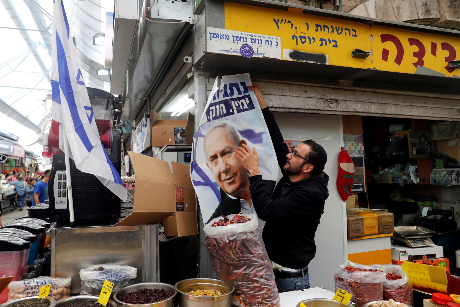 <p>A man holds a Likud election campaign poster depicting Israeli Prime Minister Benjamin Netanyahu in Jerusalem April 8, 2019. </p>
