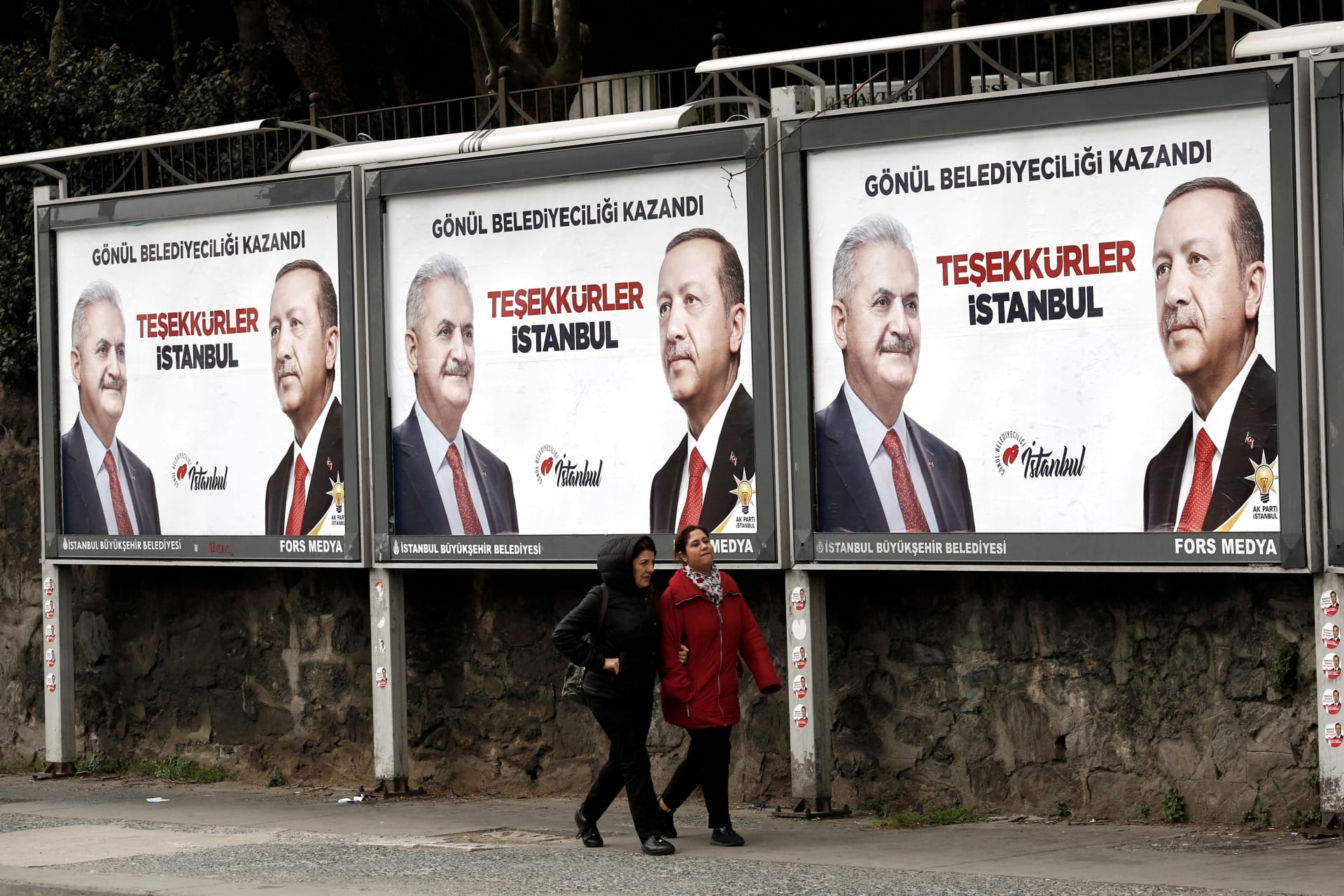 <p>People walk past by AK Party billboards with pictures of Turkish President Tayyip Erdogan and mayoral candidate Binali Yildirim in Istanbul, Turkey, April 1, 2019.</p>
