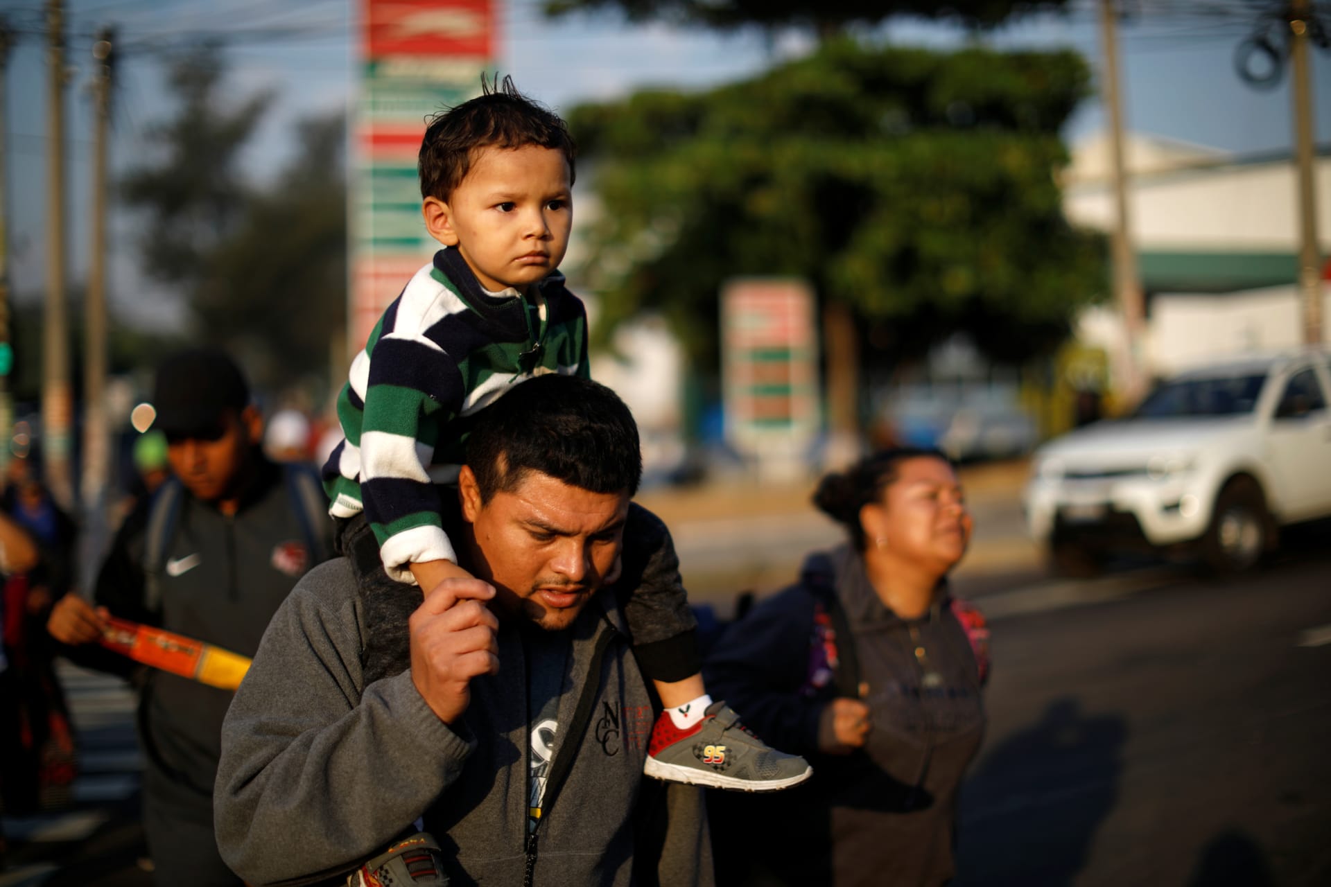 <p>Father and son walk in a caravan of migrants en route to U.S. in San Salvador</p>
