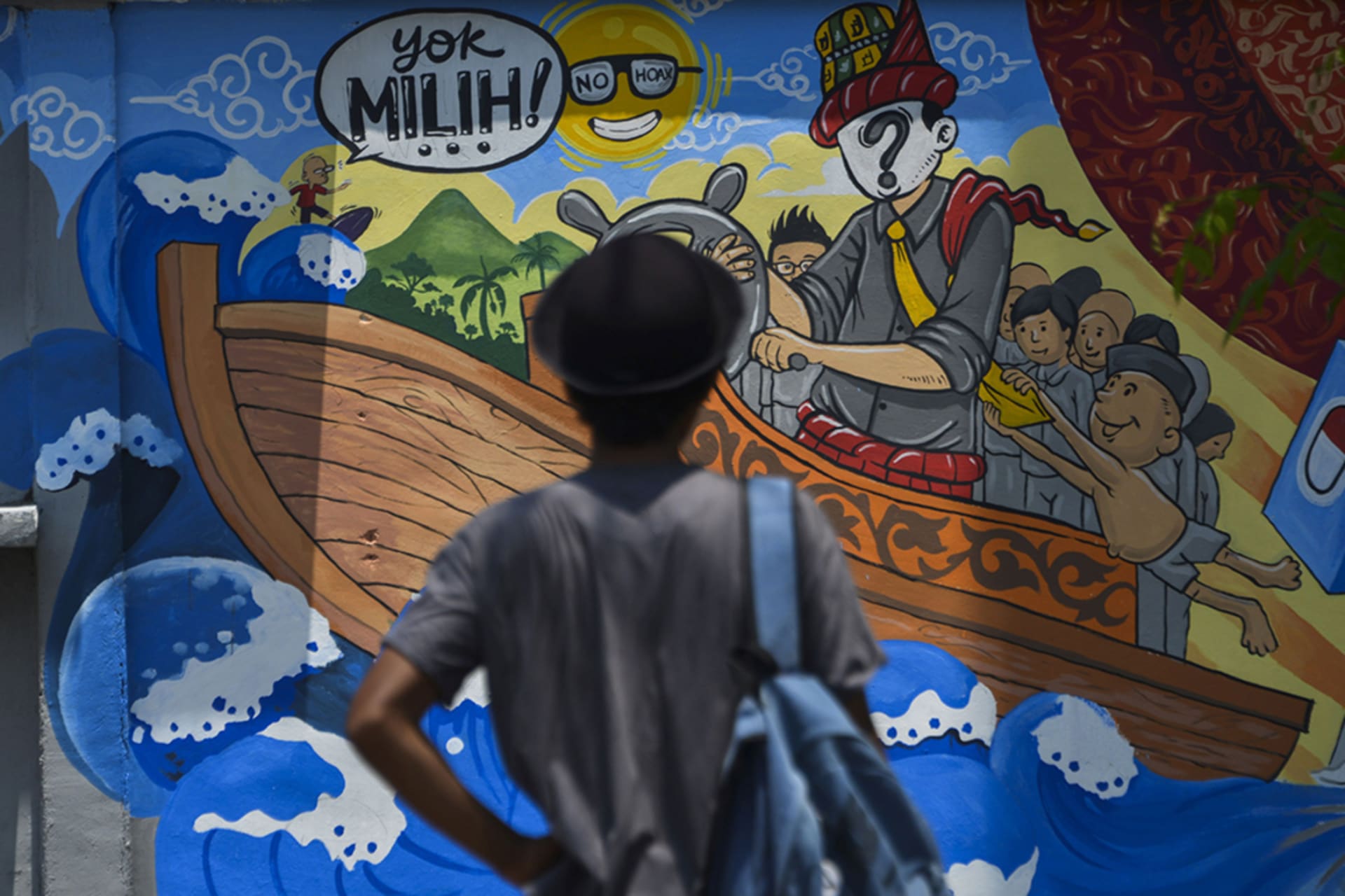 <p>A man looks at a campaign mural in Banda Aceh, Indonesia, ahead of April’s elections.</p>
