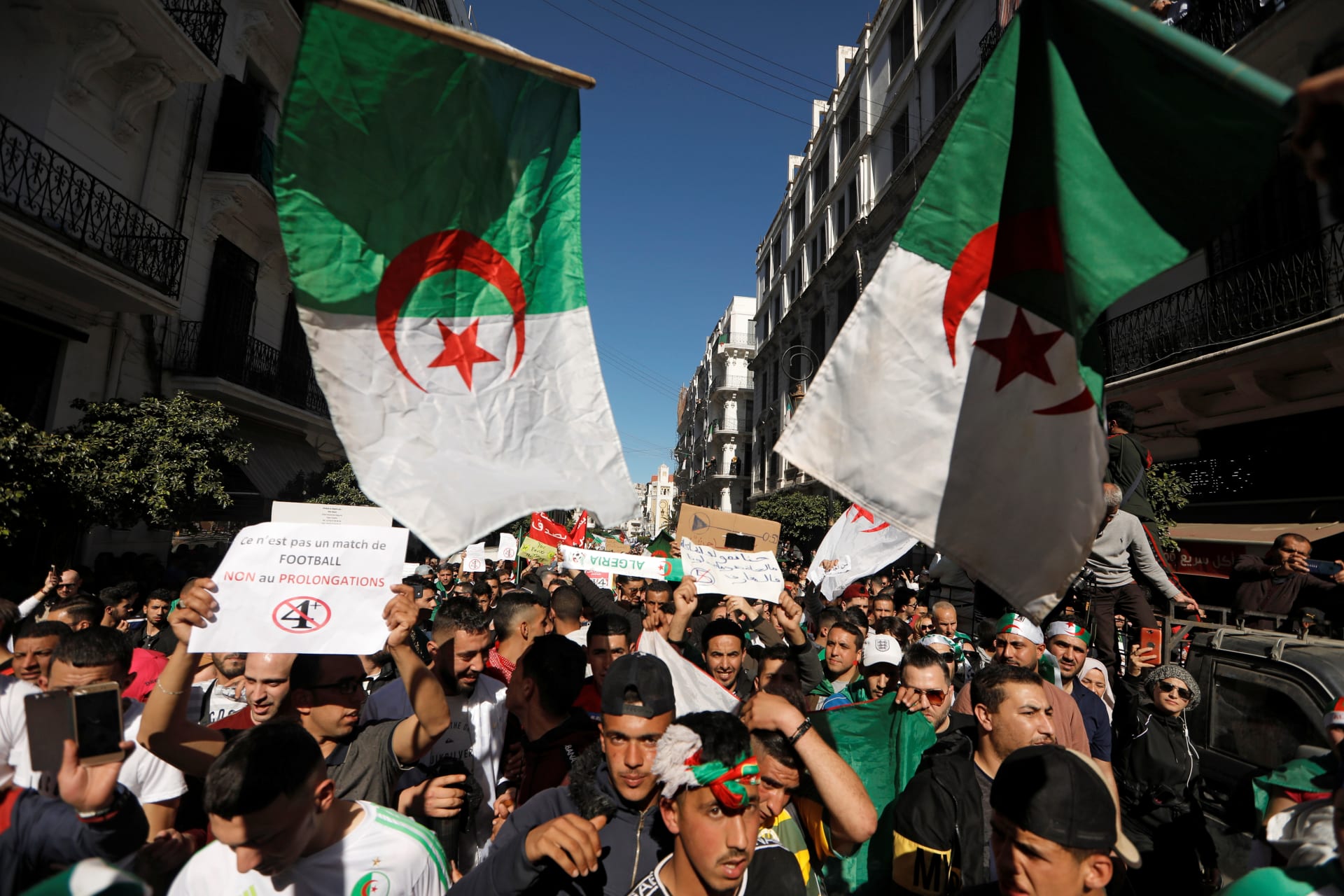<p>People carry their national flags as they gather during a protest over President Abdelaziz Bouteflika’s decision to postpone elections and extend his fourth term in office, in Algiers, Algeria March 15, 2019</p>
