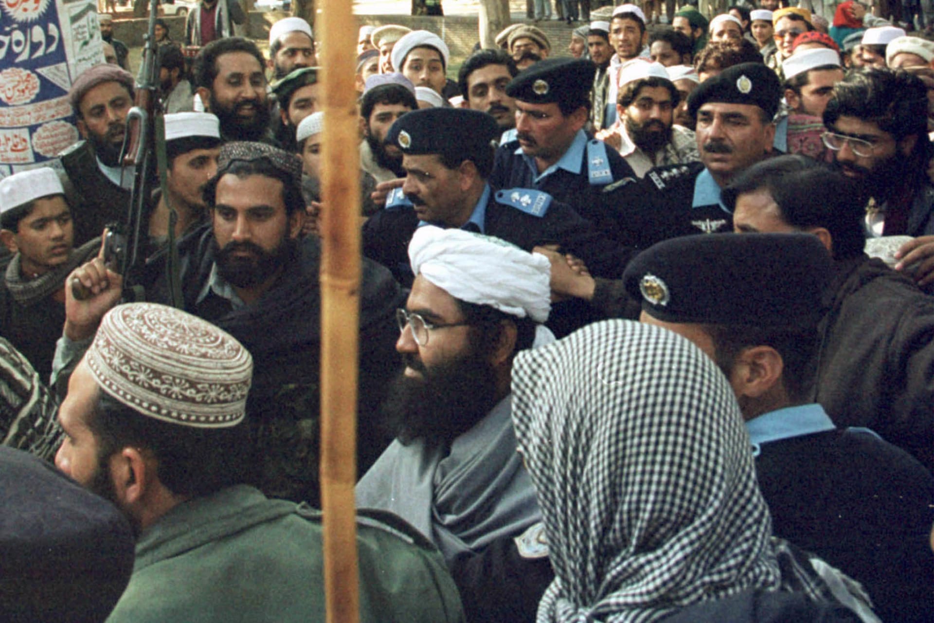 <p>Masood Azhar is surrounded by Pakistani police and his armed guards at Islamabad’s Lal Mosque (Red Mosque) in Melody Market January 27, 2000.</p>
