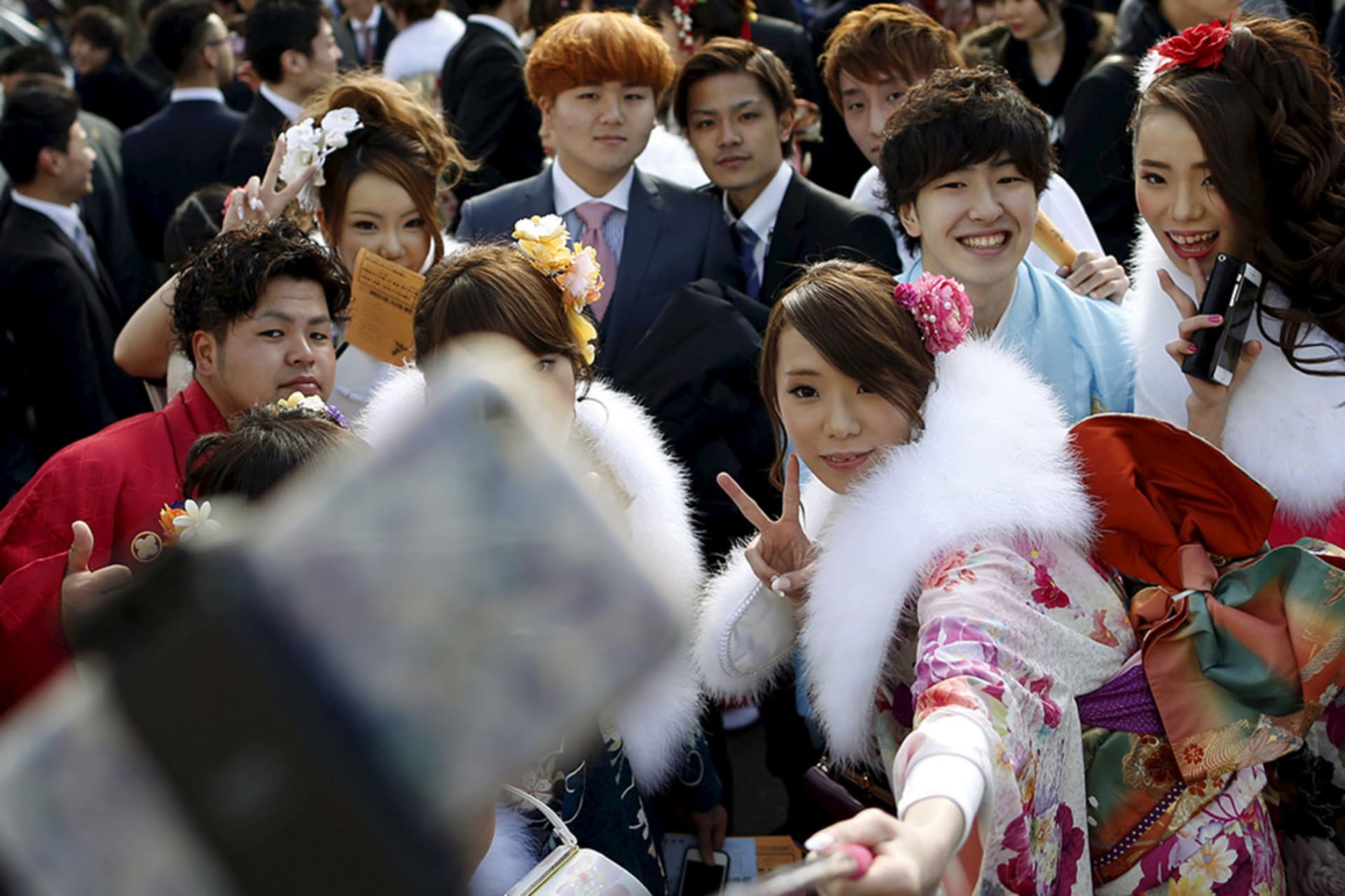 <p>Young people pose for selfies in a park in Tokyo.</p>
