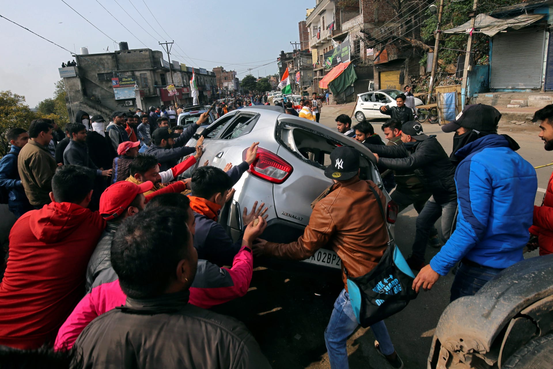 <p>Demonstrators overturn a car during a protest against the attack on a bus that killed forty-four Central Reserve Police Force personnel in Indian-administered Kashmir on Thursday, February 14, 2019. </p>
