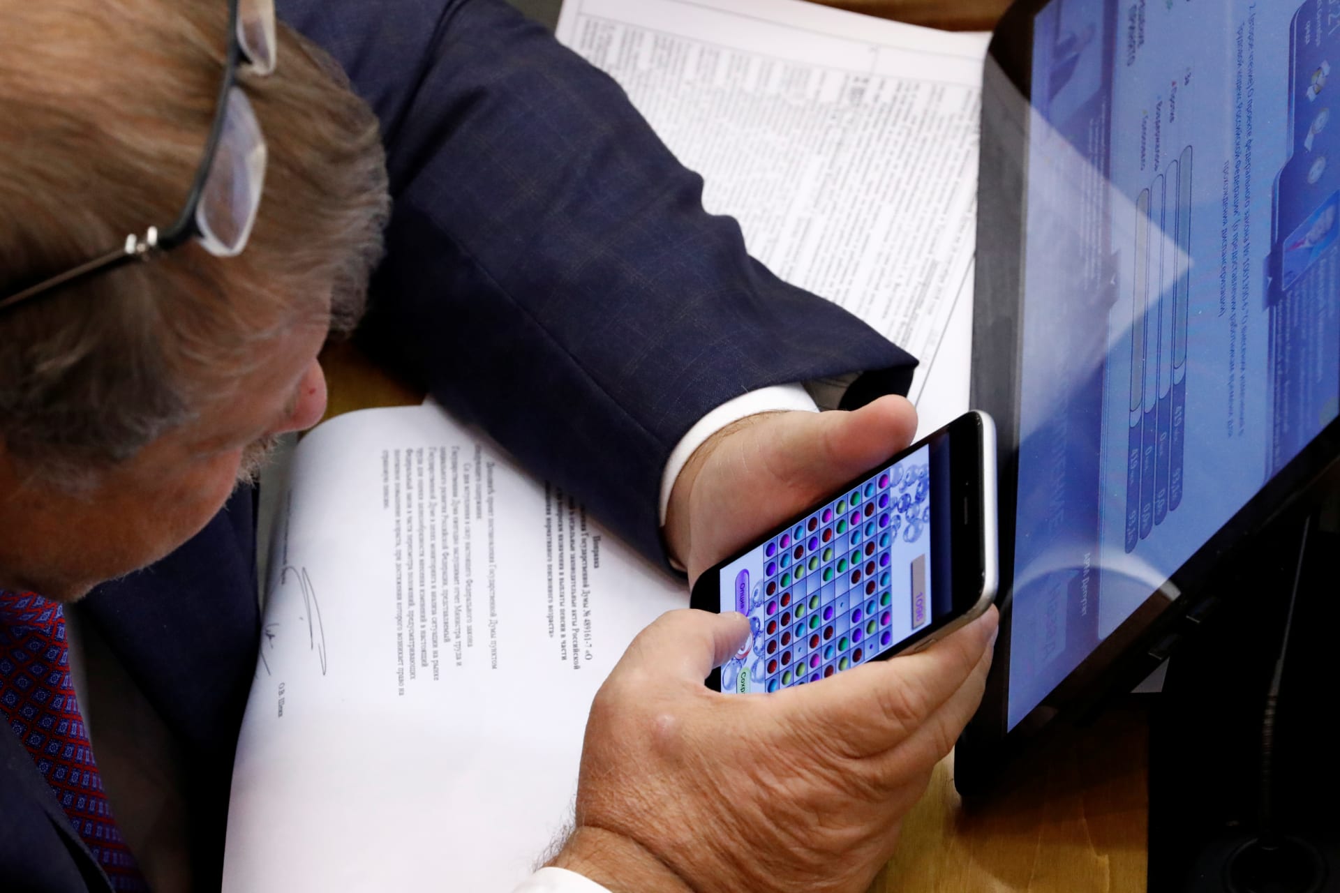 <p>A Russian lawmaker plays a game on his mobile phone during a vote on the pension reform bill at the State Duma, the lower house of parliament, in Moscow Russia September 26, 2018. </p>
