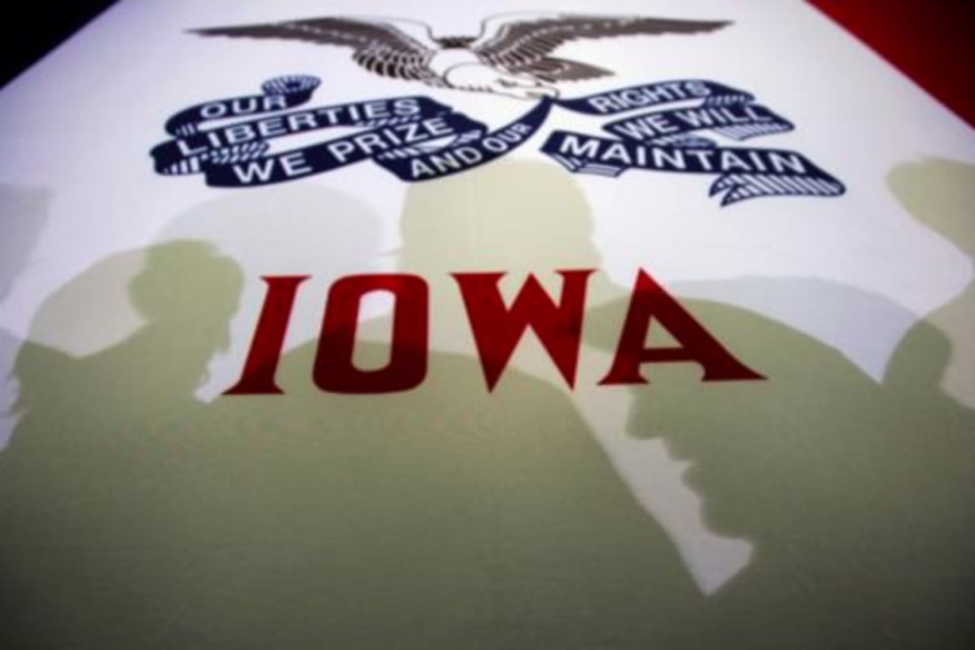 <p>Potential caucus voters cast shadows on an Iowa state flag at a campaign rally in Clive, Iowa, January 2, 2012.</p>
