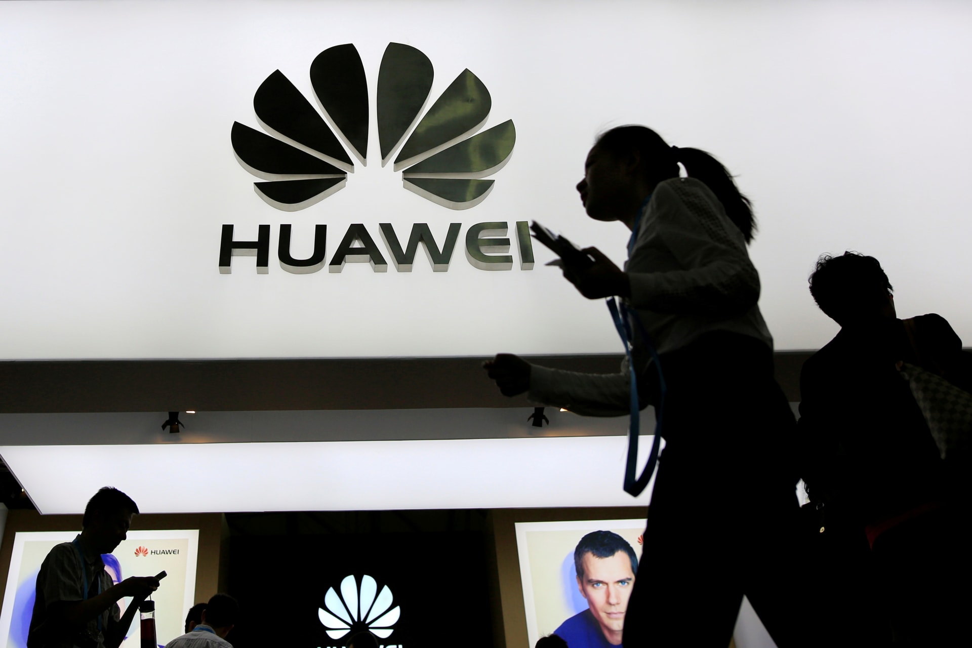 <p>People walk past a sign board of Huawei at CES (Consumer Electronics Show) Asia 2016 in Shanghai, China.</p>
