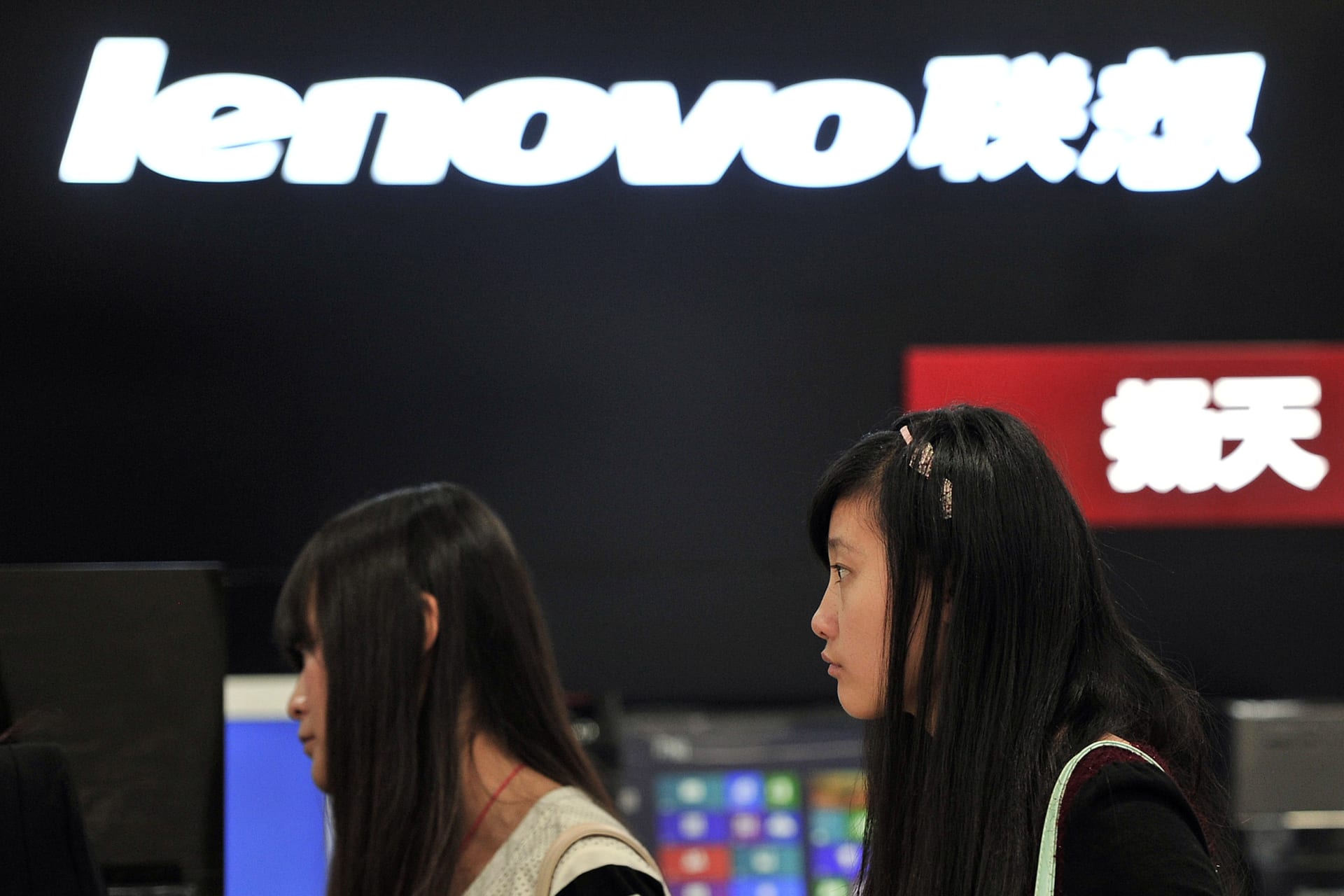 <p>People walk past a Lenovo shop in Hefei, Anhui province</p>
