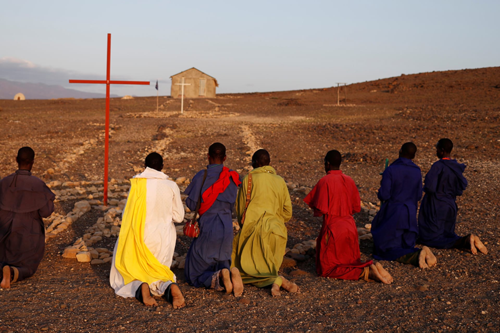 <p>Turkana men pray outside a Legio Maria African Mission Church in Loiyangalani, Kenya, on August 5, 2017.</p>
