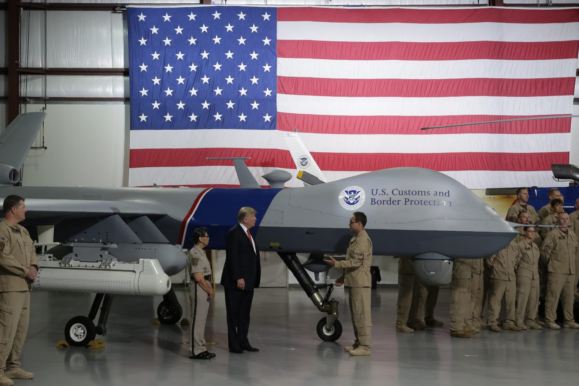 <p>U.S. President Donald Trump puts his hand on a drone aircraft used to patrol the border at U.S. Customs and Border Patrol facility in Yuma, Arizona, U.S., August 22, 2017.</p>
