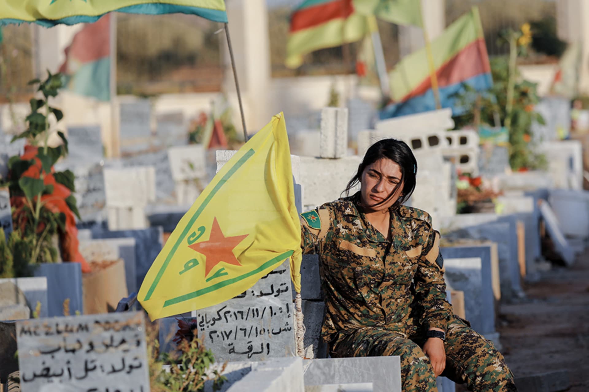 <p>Fighters of the Syrian Democratic Forces visit the graves of their late comrades at a cemetery in Kobani, Syria.</p>
