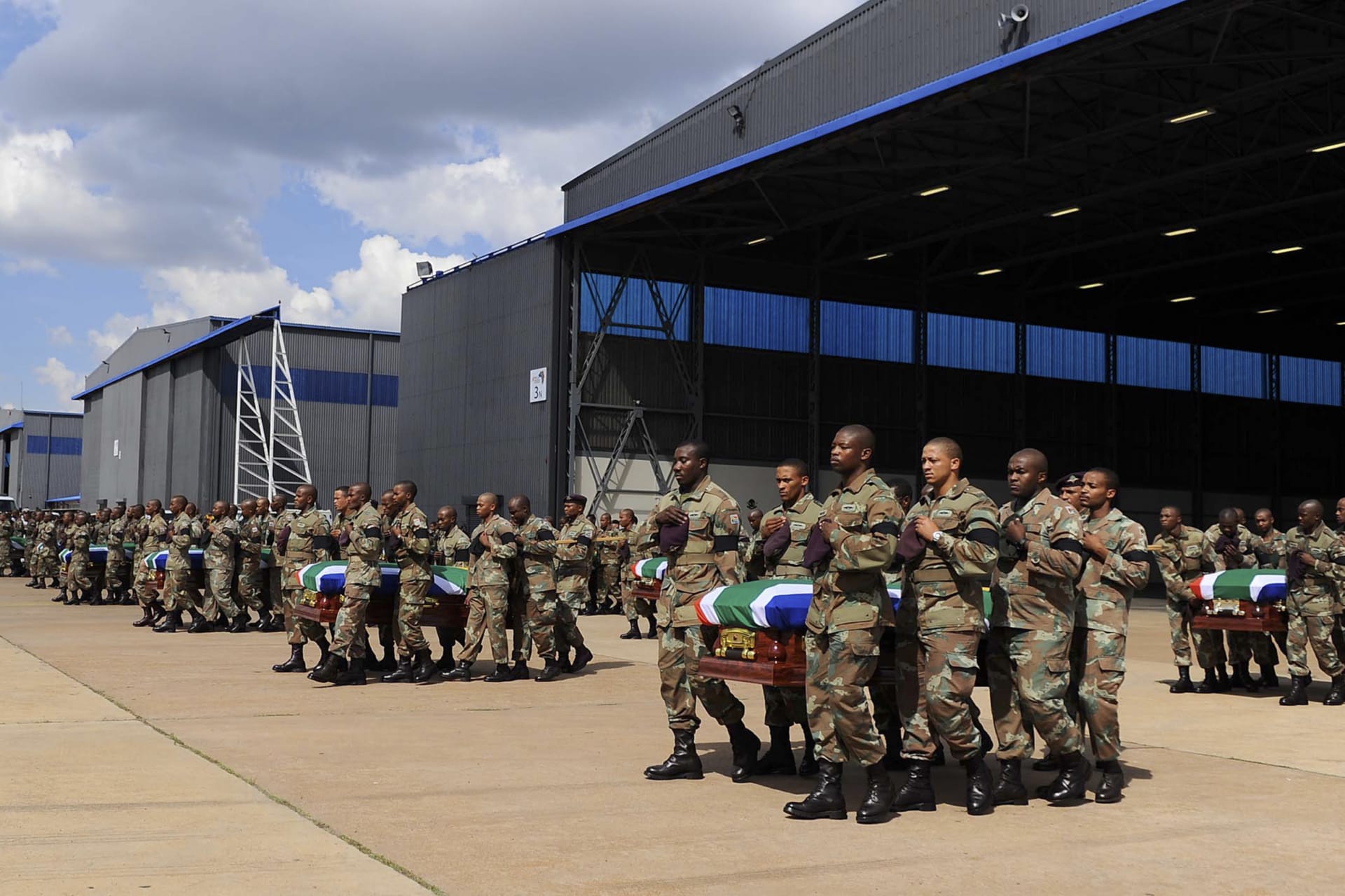 <p>Members of the South Africa National Defense Force (SANDF) carry the remains of 13 members that were killed in Central African Republic (CAR) during the handing over to the respective families at the Waterkloof Air Force Base, Pretoria, on March 28, 2013.</p>
