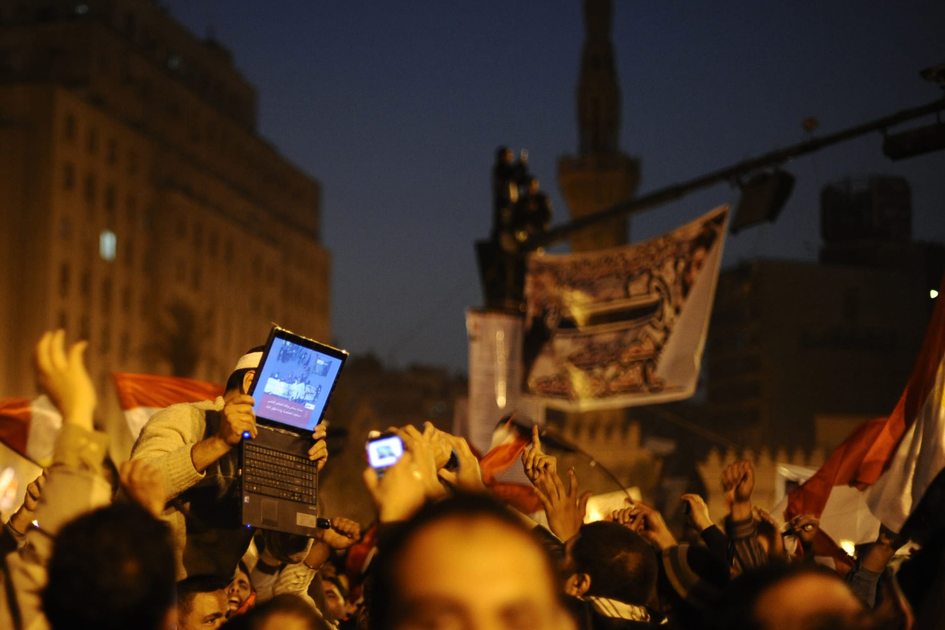 <p>An opposition supporter holds up a laptop showing images of celebrations in Cairo’s Tahrir Square, after Egypt’s President Hosni Mubarak resigned February 11, 2011</p>
