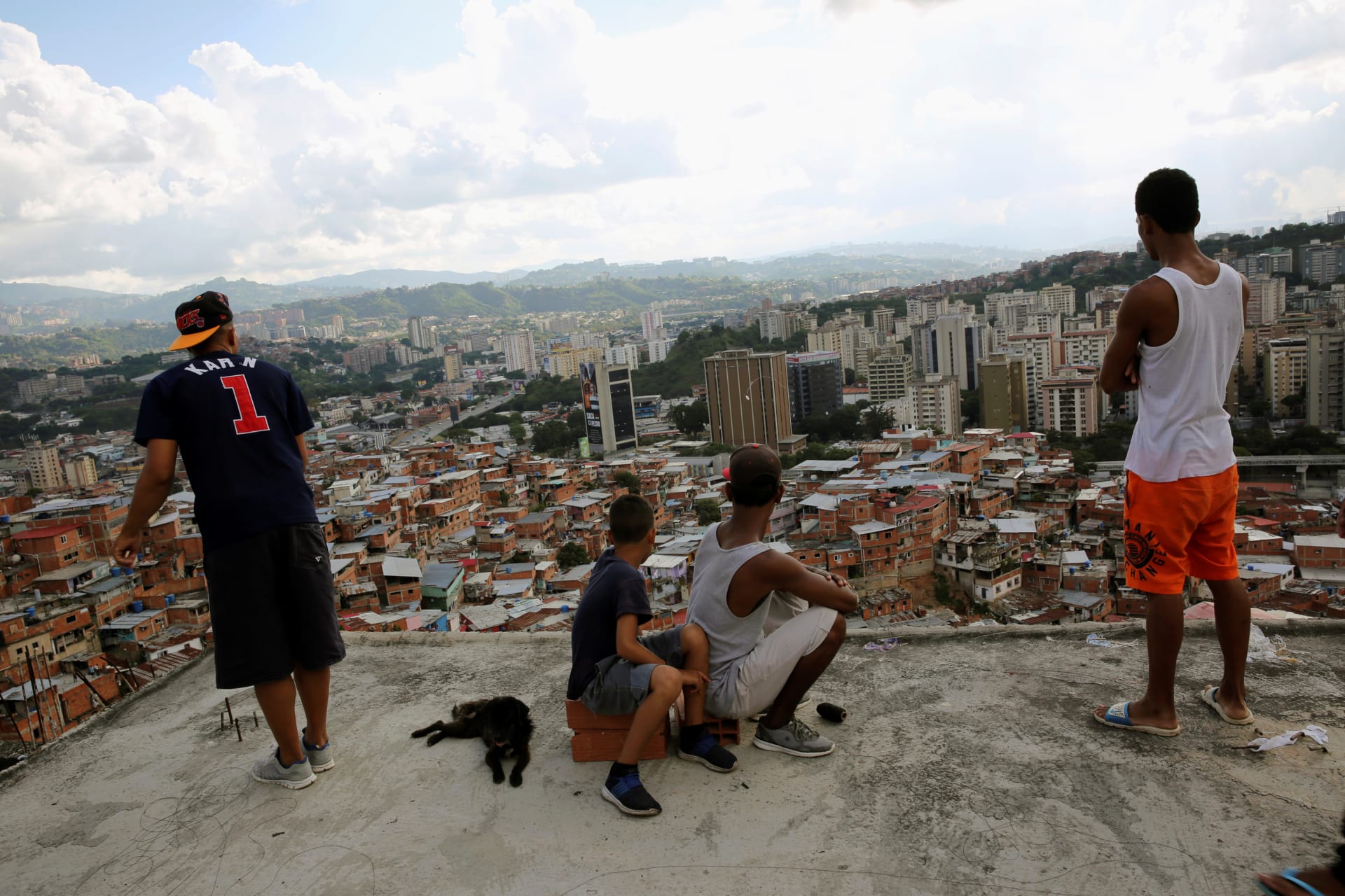 <p>Four boys look ahead as one flies a kite over houses in the Petare slum in Caracas, Venezuela. </p>
