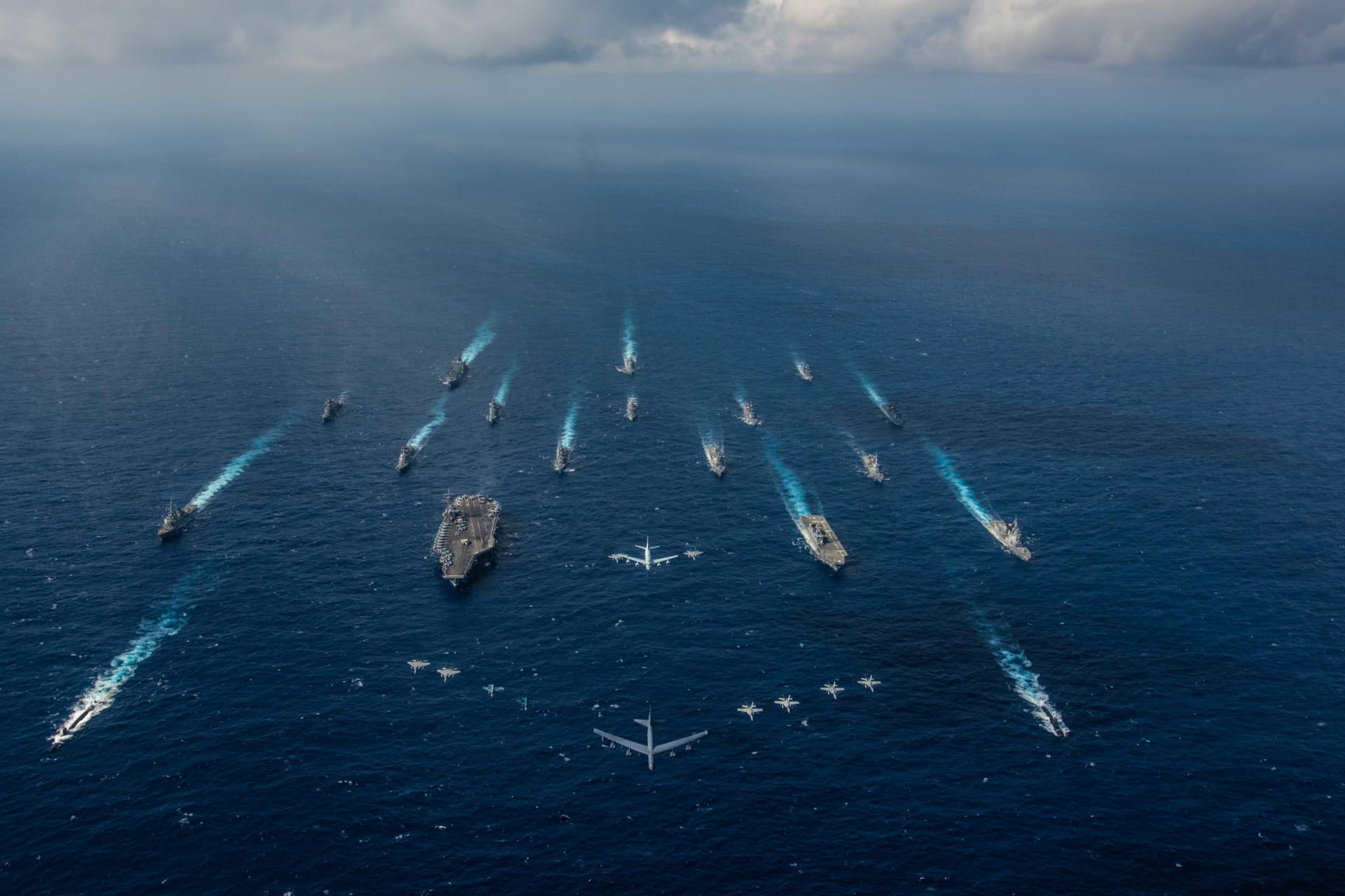 <p>Ships from the U.S. Navy and the Japan Maritime Self-Defense Force sail as aircraft from the U.S. Air Force and Japan Air Self-Defense Force fly overhead in the Philippine Sea on November 8, 2018.</p>
