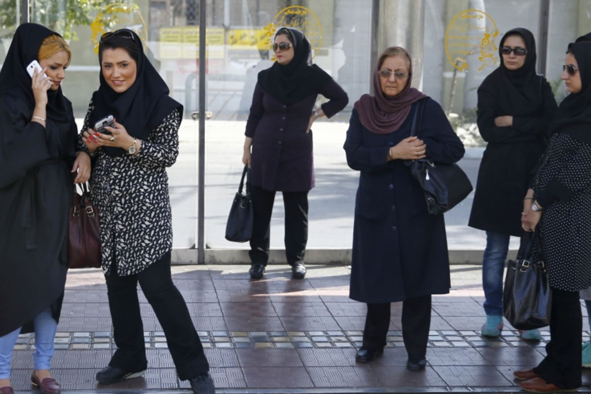 <p>Women wait for a bus in central Tehran, Iran.</p>
