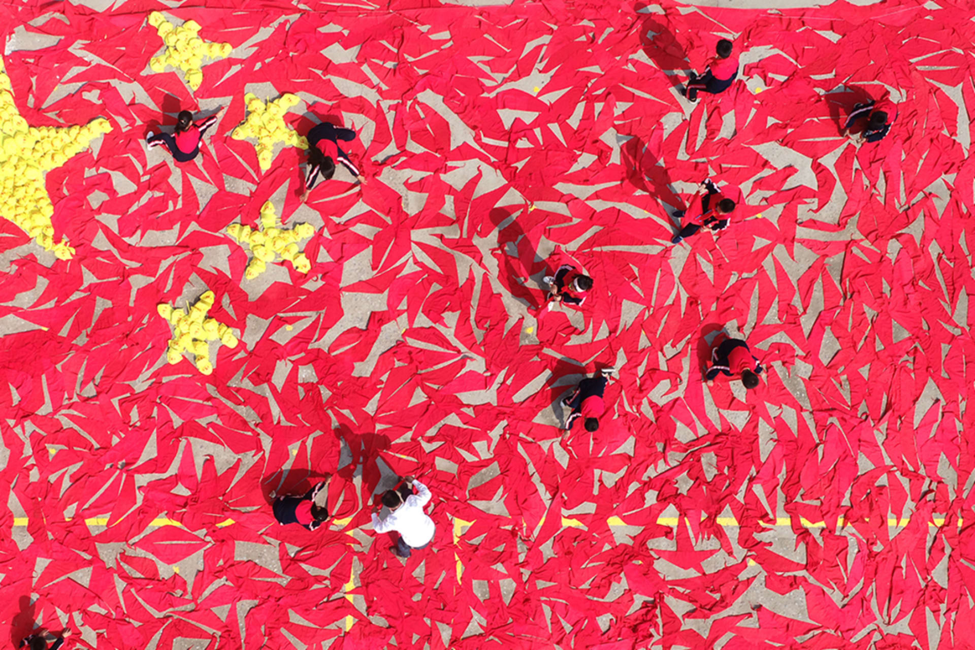 <p>Students use red scarves and yellow hats to make the pattern of the Chinese national flag at a primary school in Linyi, Shandong Province. </p>
