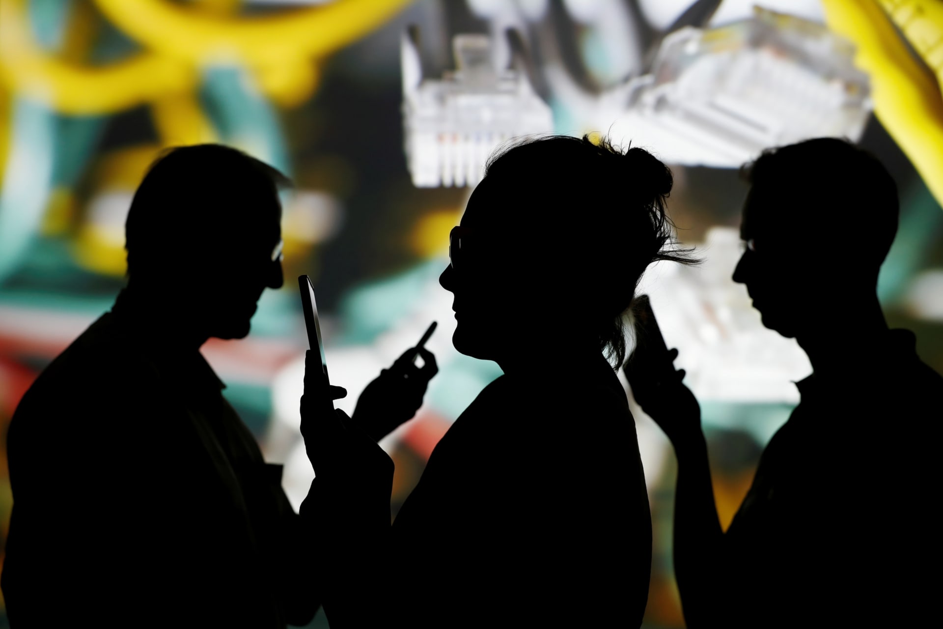 <p>People look at data on their mobiles as background with internet wire cables on switch hub is projected in this picture illustration taken May 30, 2018.</p>