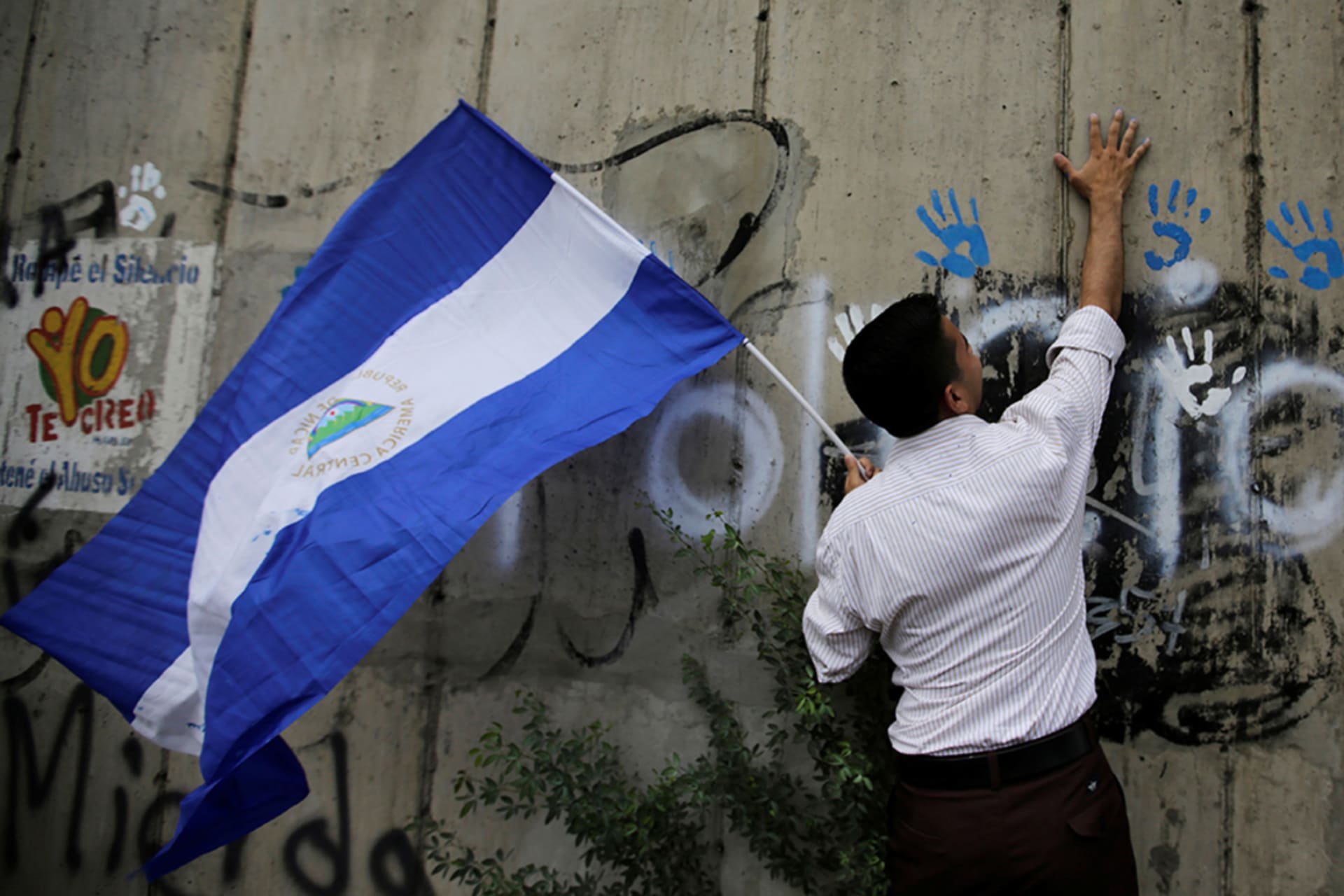<p>A demonstrator places his painted handprints on a wall during a gathering to mark one hundred days of anti-government protests aimed to oust Nicaragua’s President Daniel Ortega, in Managua.</p>
