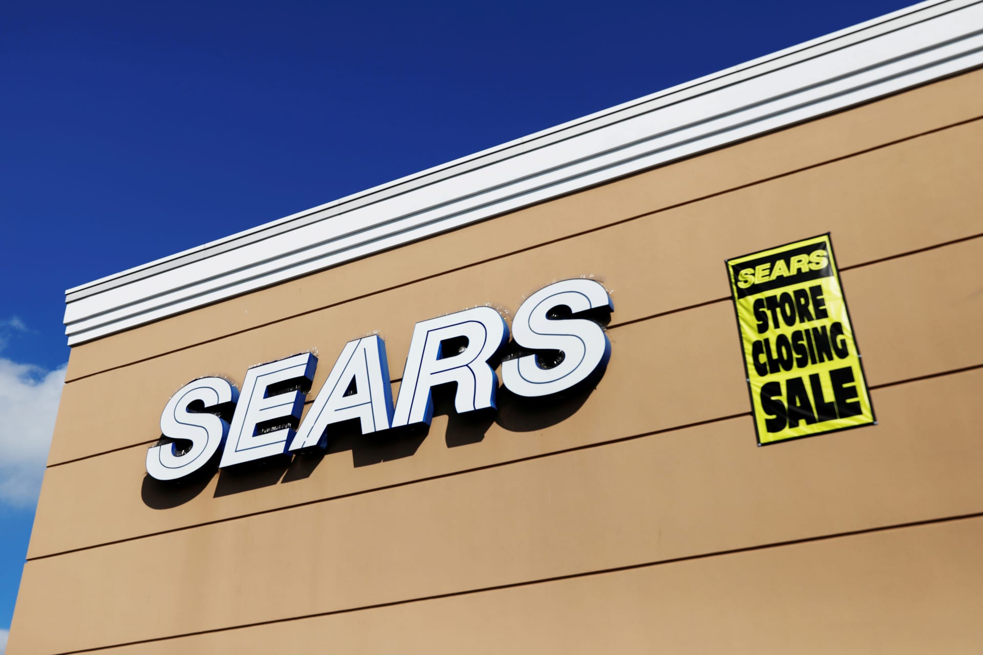<p>A store closing sale sign is posted next to a Sears logo in New Hyde Park, New York.</p>
