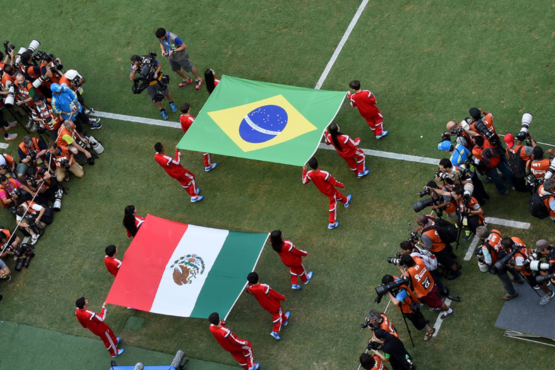 <p> Flag bearers carry the Mexican and Brazilian flags out onto the pitch prior to the 2014 FIFA World Cup Brazil Group A match between Brazil and Mexico at Castelao on June 17, 2014 in Fortaleza, Brazil.</p>

