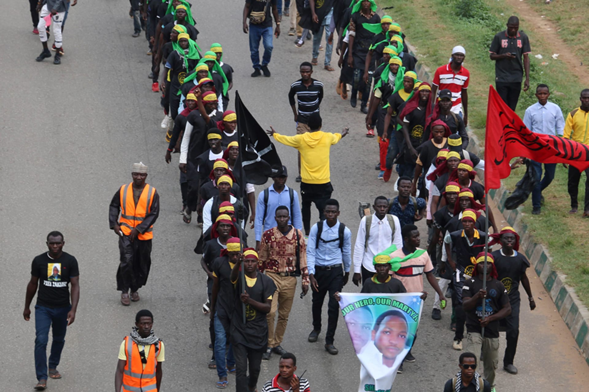 <p>Members of Islamic Movement of Nigeria (IMN) wave flags and chant slogans as they take part in a demonstration to protest against an imprisoned Shiite cleric, in Abuja, on October 29, 2018.</p>
