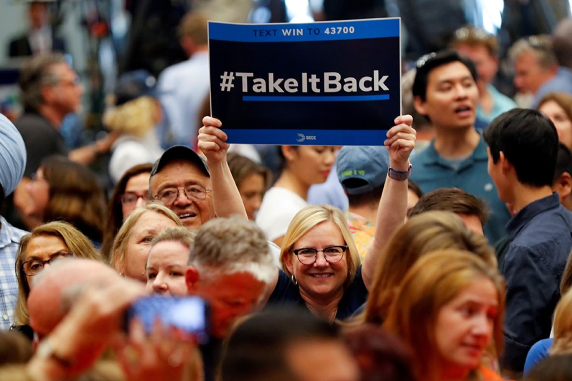 <p> A woman holds up a “Take It Back” sign at a political rally with former President Barack Obama in Anaheim, California.</p>

