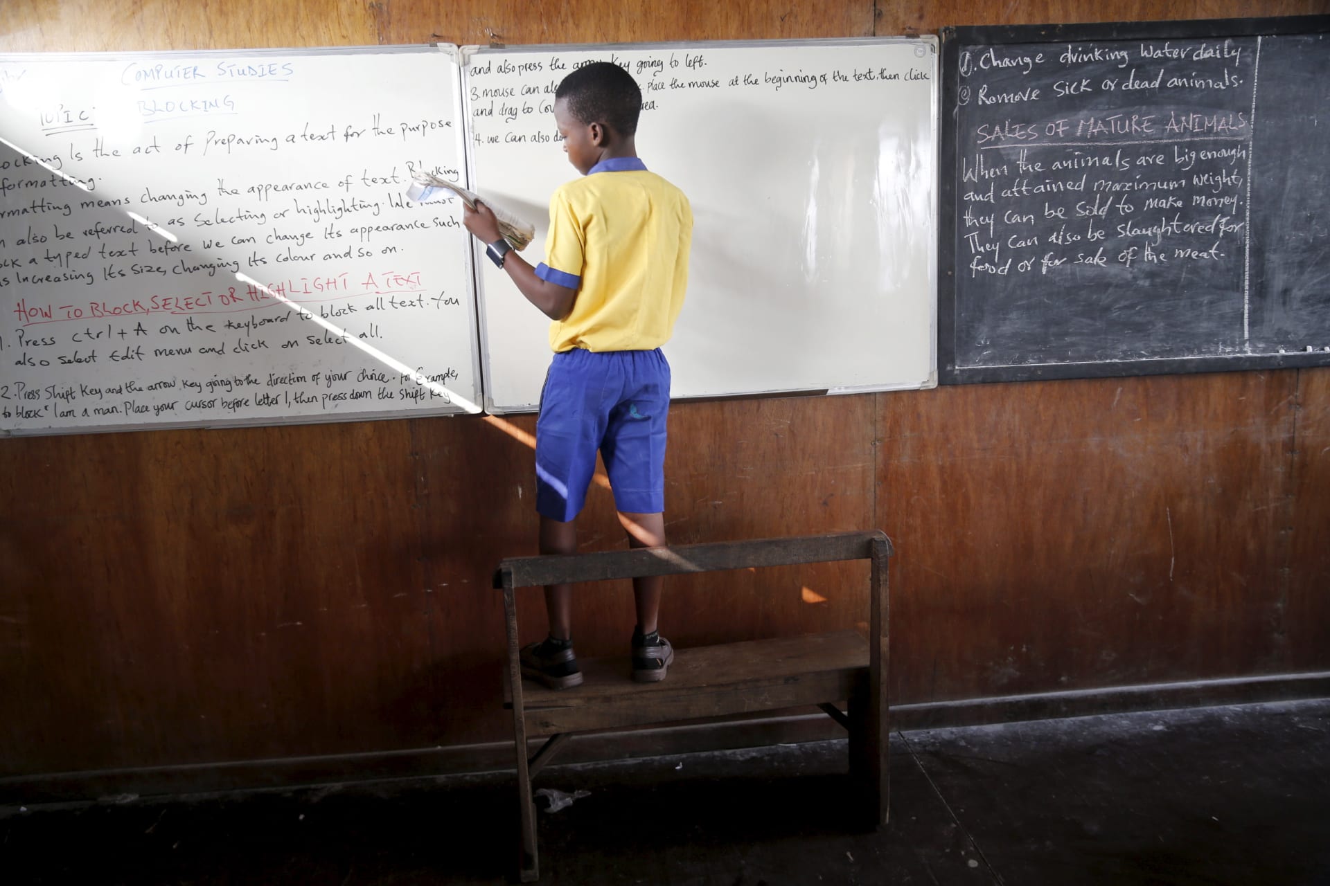 <p>A student stands on a bench to write on the board at a floating school in the Makoko fishing community on the Lagos Lagoon, Nigeria February 29, 2016. In Makoko is a sprawling slum of Nigeria’s megacity Lagos, and the school provides free educatio.</p>
