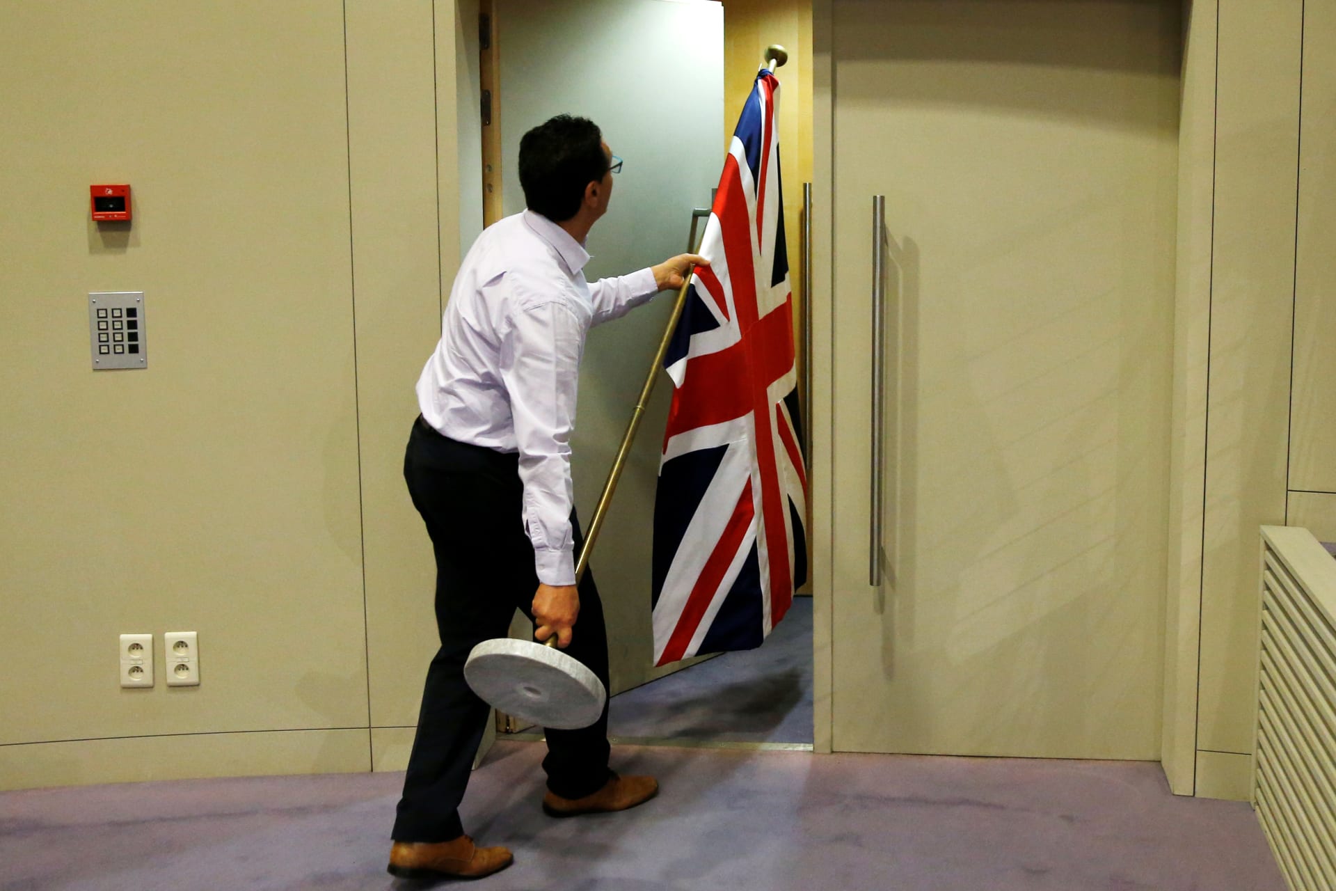 <p>An official carries a Union Jack flag ahead of a news conference by Britain’s Secretary of State for Exiting the European Union David Davis and European Union’s chief Brexit negotiator Michel Barnier in Brussels, Belgium on July 20, 2017.</p>
