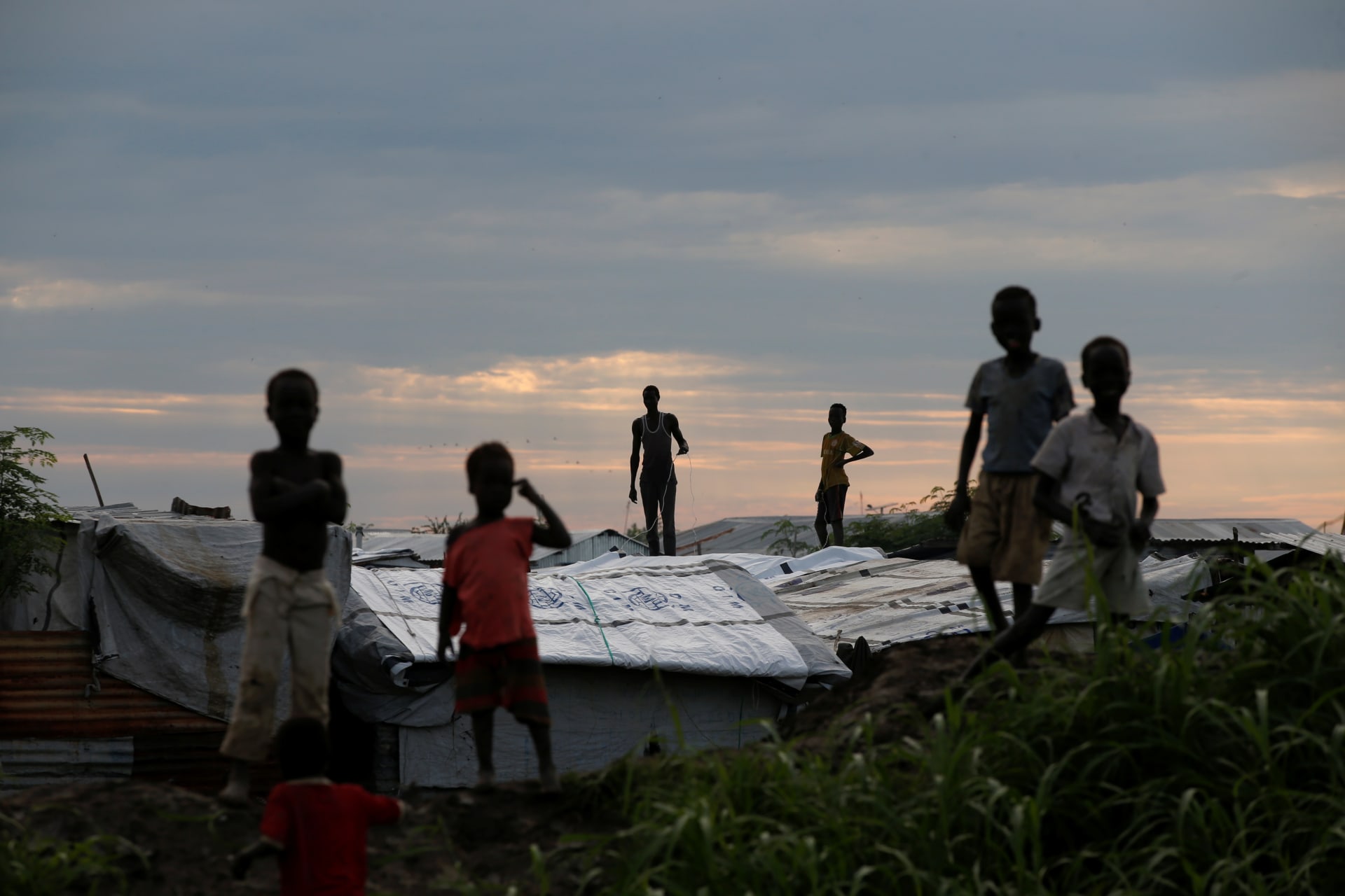 <p>Internally displaced people stand on roofs in the Protection of Civilians Camp run by the UN Mission in South Sudan on September 8, 2018. </p>
