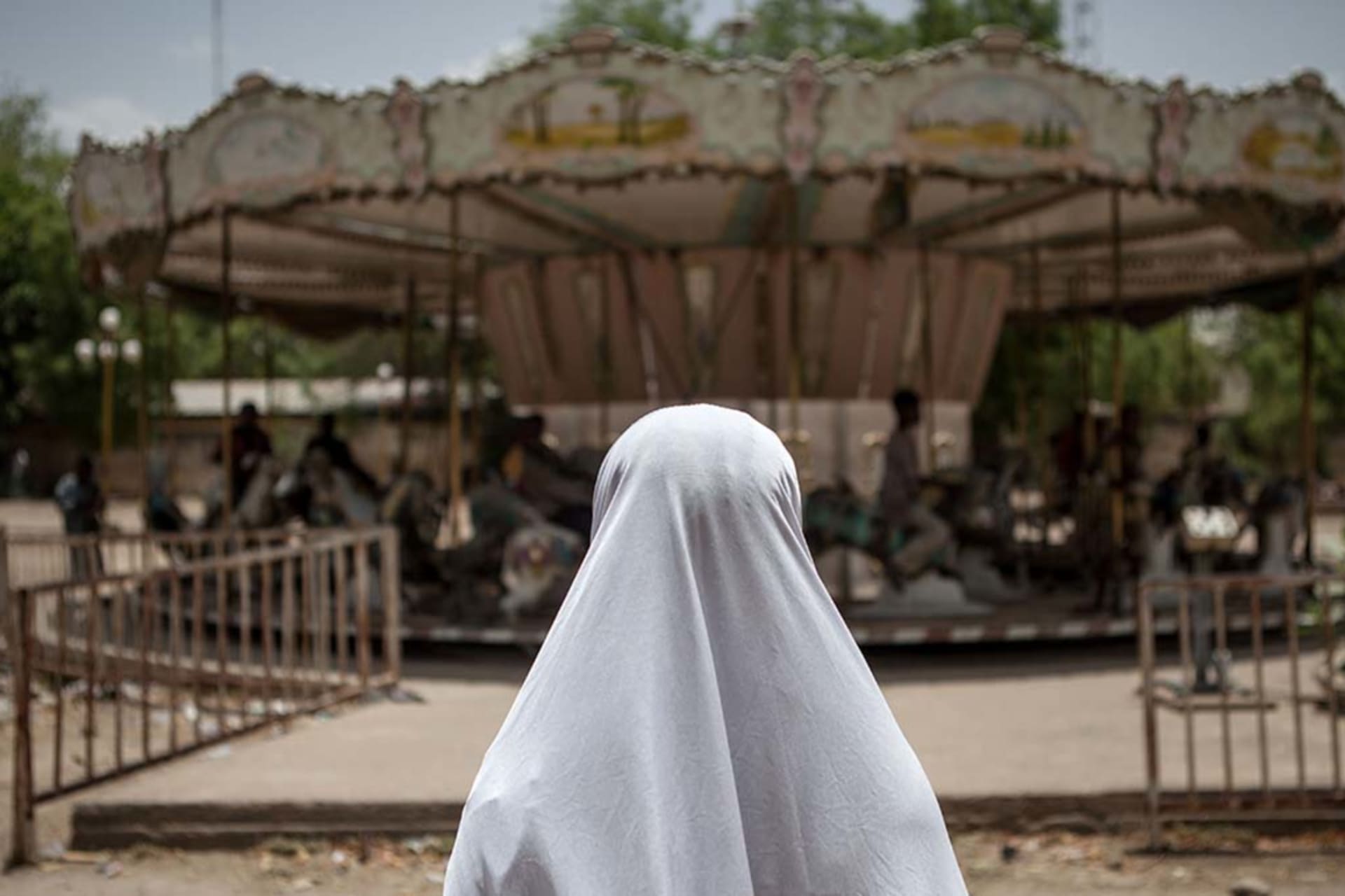 <p>A girl watches a merry-go-round at an abandoned amusement park in Maiduguri, Nigeria.</p>

