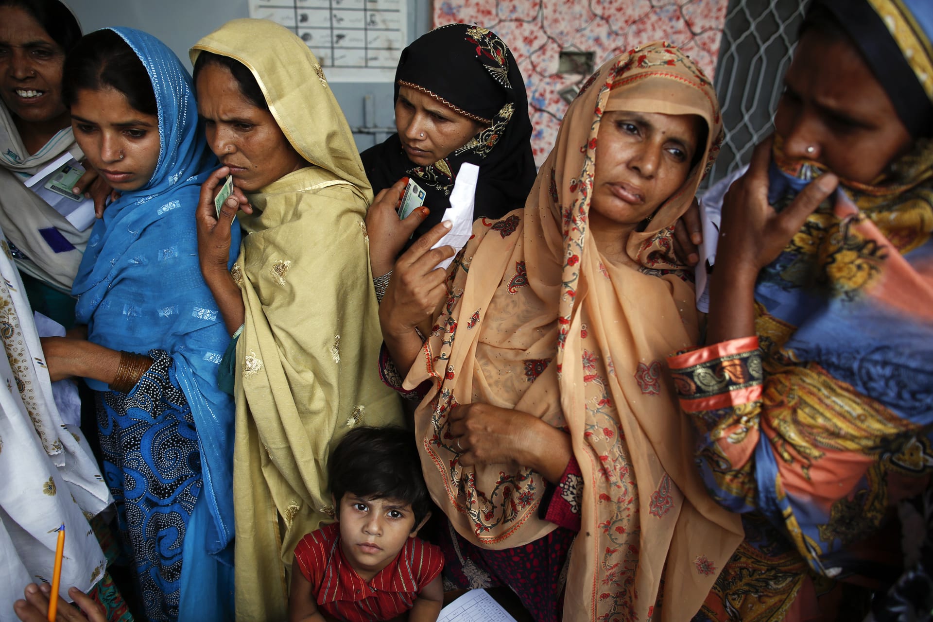 <p>Women wait to vote at a polling station in a village near Lahore in 2013.</p>
