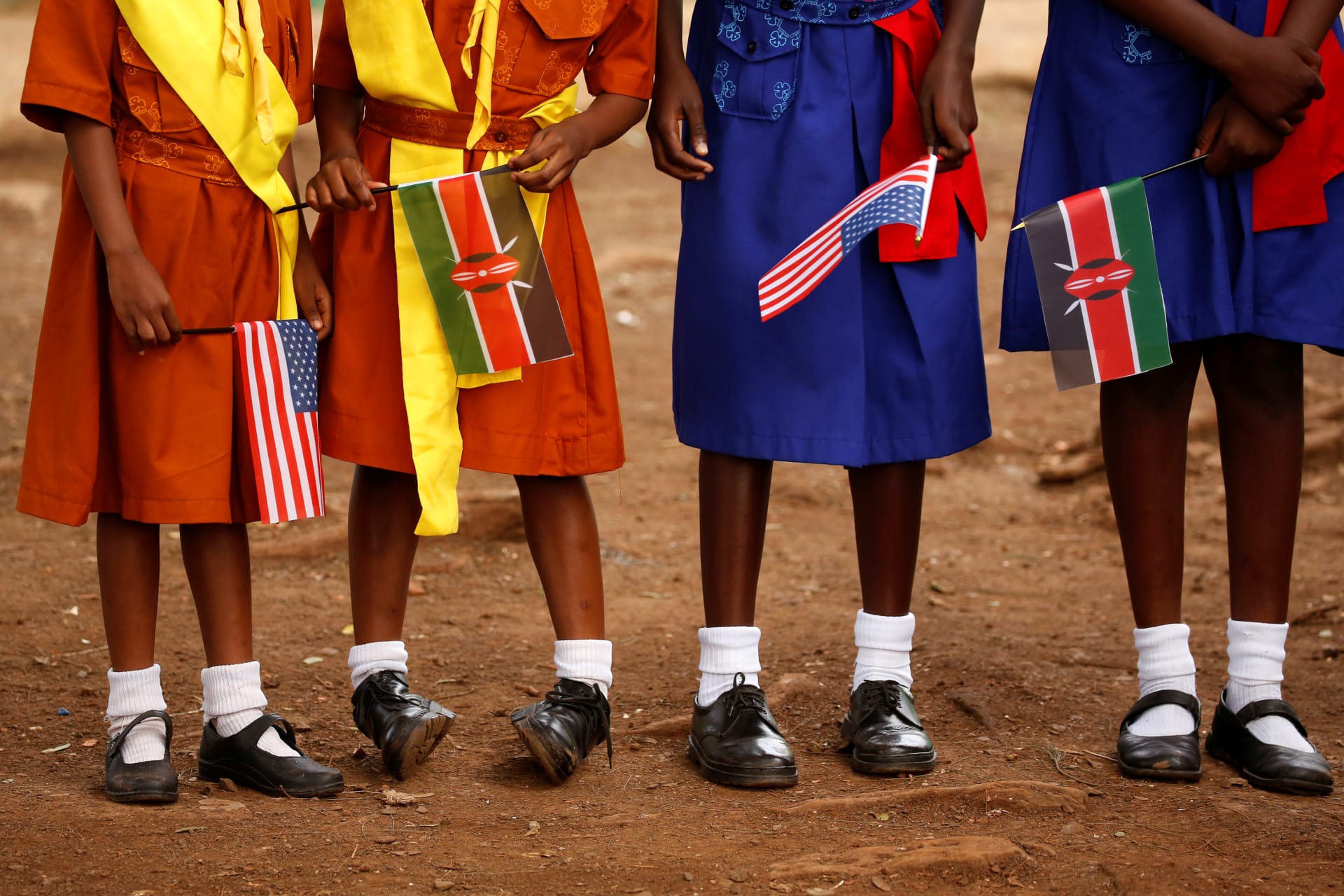 <p>Girls with U.S. and Kenya flags wait to greet U.S. Ambassador to Kenya as he visits a President’s Emergency Plan for AIDS Relief (PEPFAR) project for girls’ empowerment in Nairobi, Kenya.</p>
