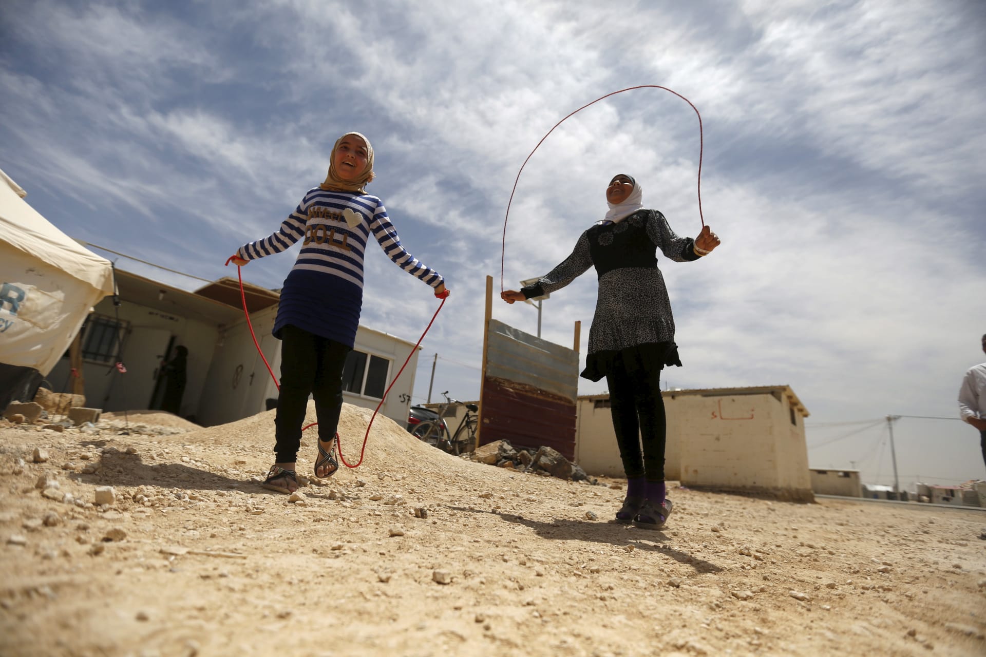 <p>Syrian refugee Omayma al Hushan (R), 14, who launched an initiative against child marriage among Syrian refugees, plays with her friend outside their residence in Al Zaatari refugee camp.</p>
