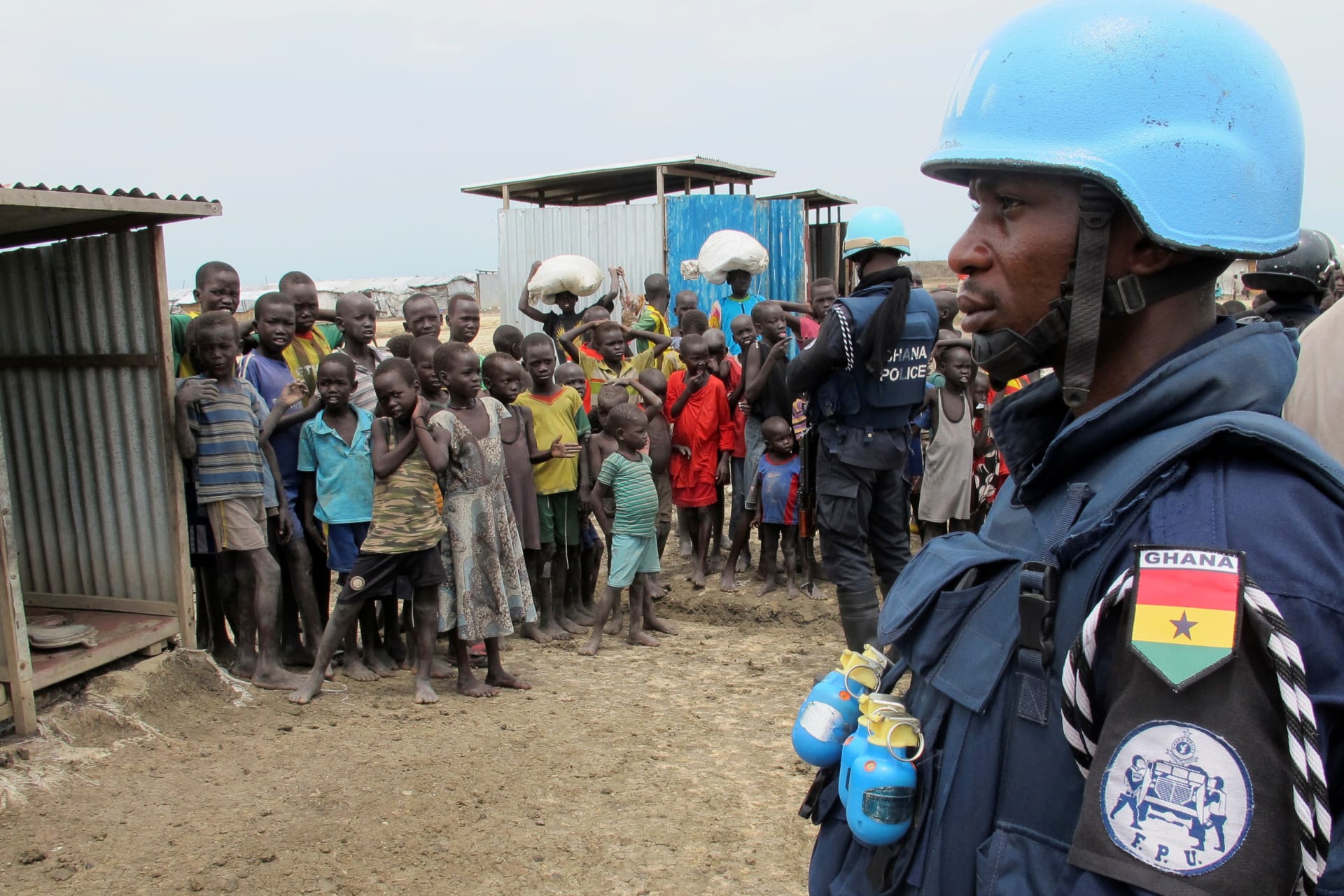 <p>A Ghanaian UN peacekeeper stands watch as children look on at a protection camp for displaced civilians in Bentiu, South Sudan June 18, 2017.</p>
