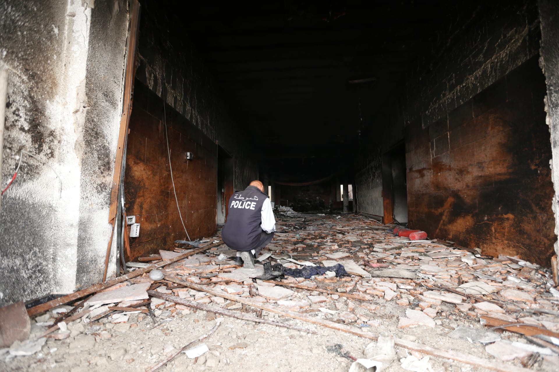 <p>A security personnel inspects the site of a suicide attack on the electoral commission in Tripoli, Libya May 2, 2018</p>
