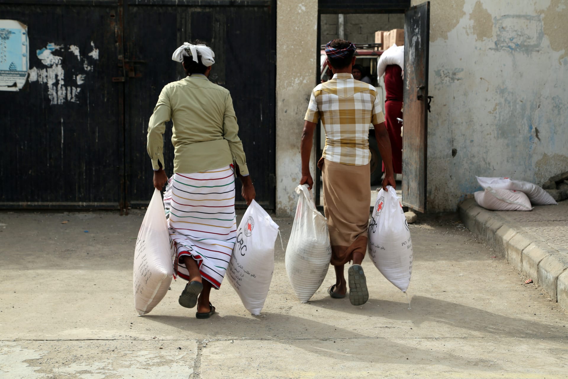 <p>Displaced people receive aid kits distributed by the International Committee of the Red Cross in the war-torn Red Sea port city of Hodeidah, Yemen on June 21, 2018. </p>
