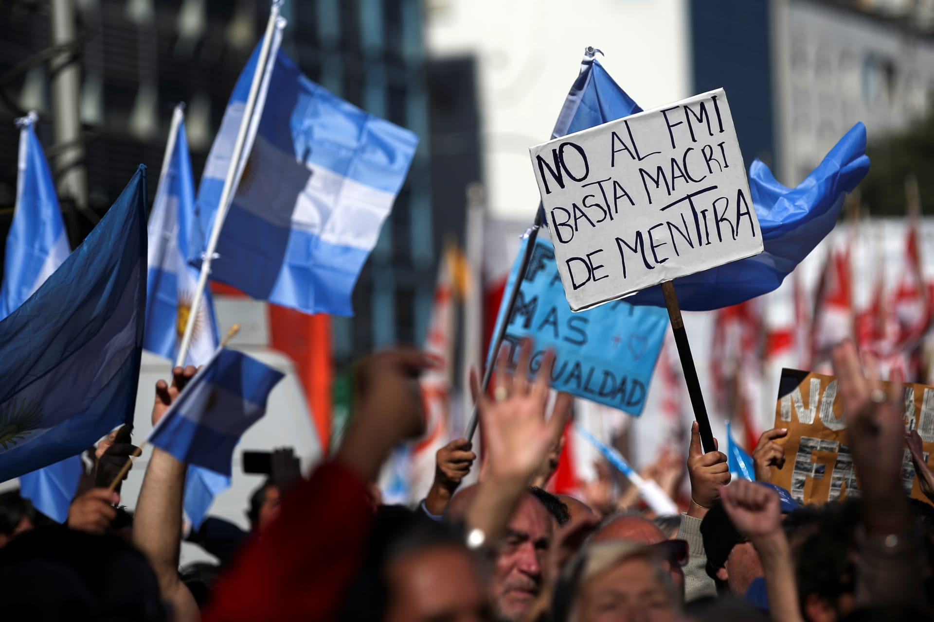 <p>People walk past a grafitti that reads “IMF (International Monetary Fund), never again” during a demonstration to demand jobs and social benefits in Buenos Aires, Argentina, June 1, 2018.</p>
