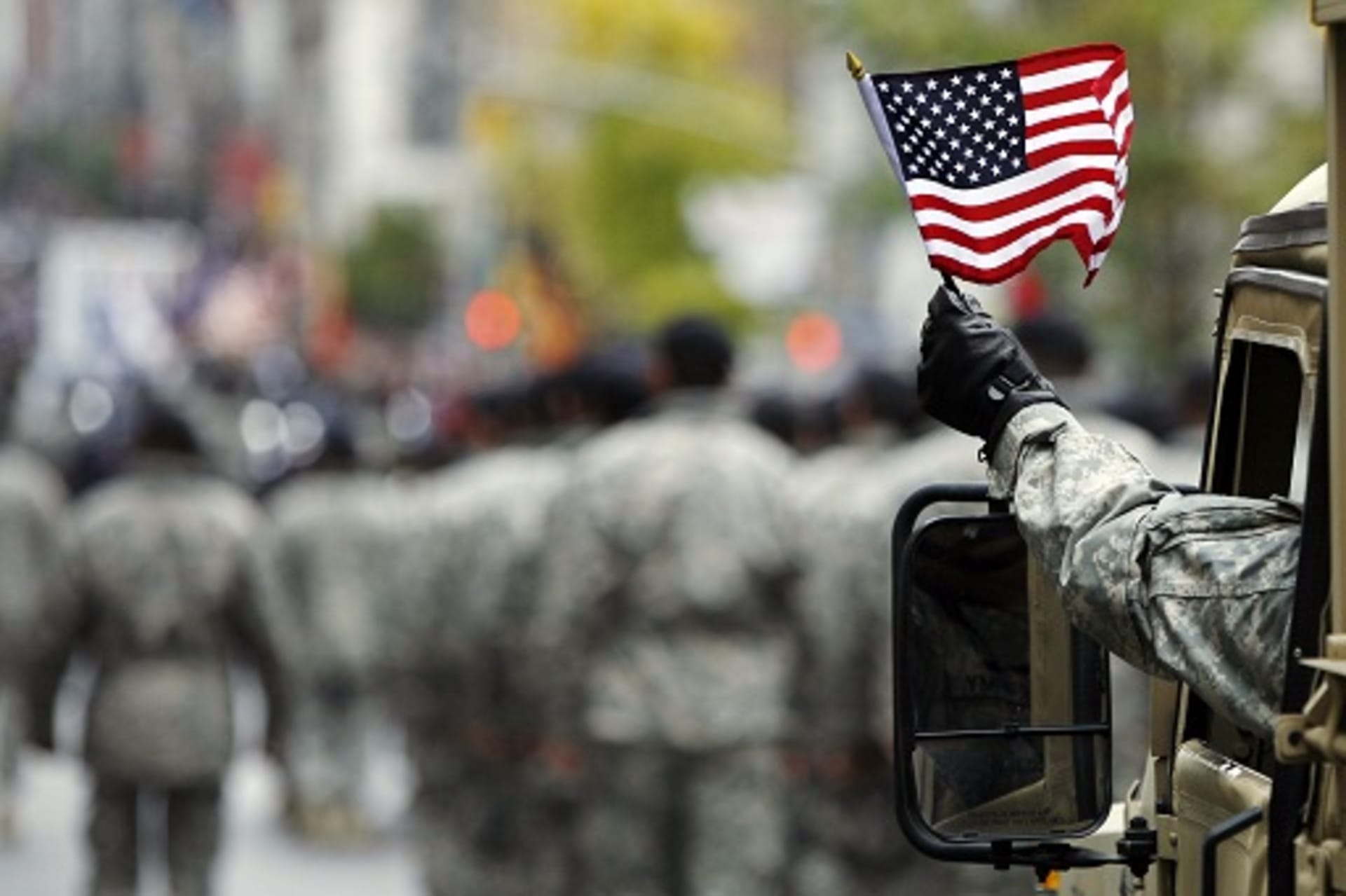 <p>U.S. Army serviceman waves an American flag during a Veterans Day parade in New York. </p>

