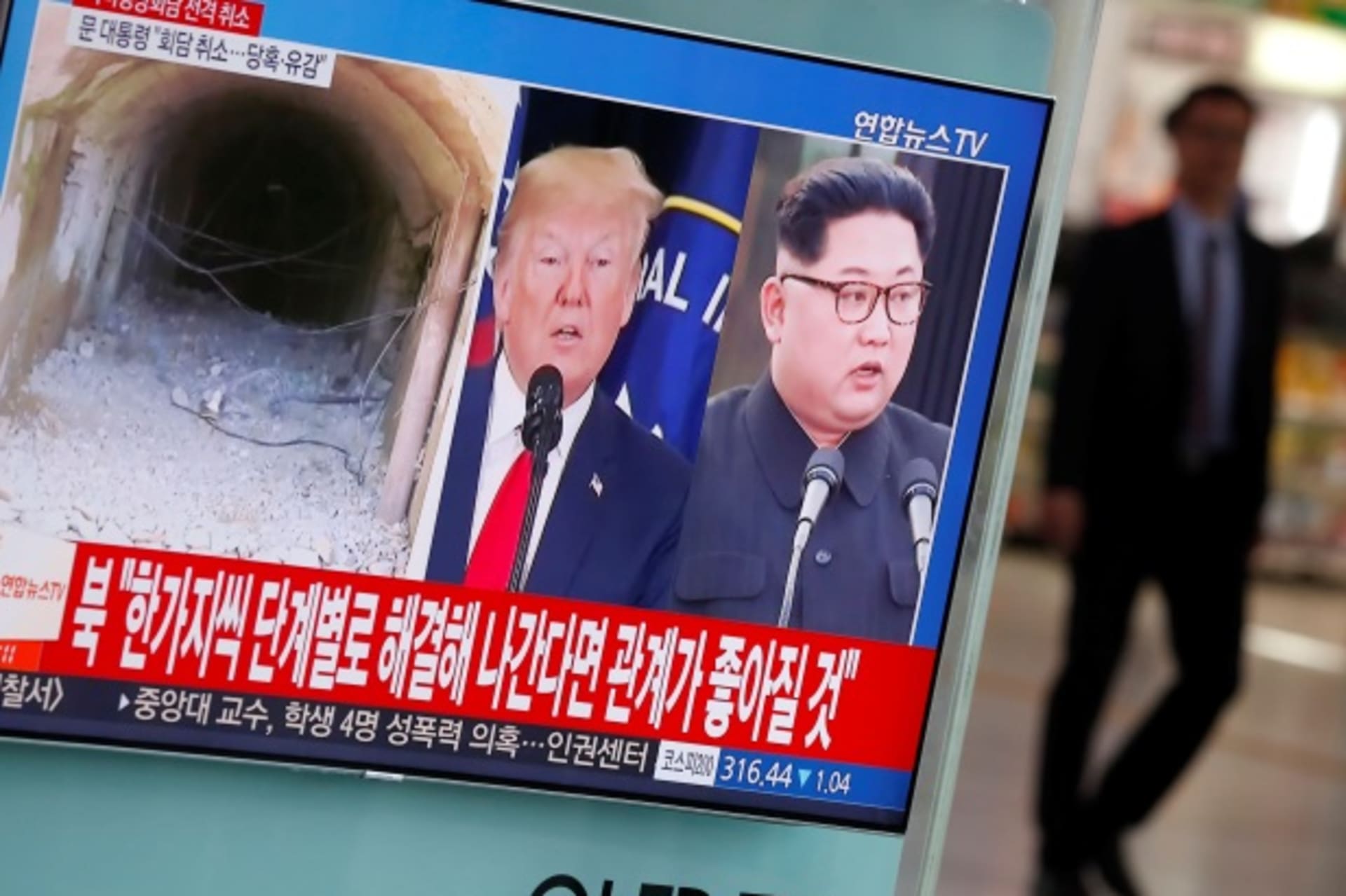 <p>A man walks past a TV broadcasting a news report on a cancelled summit between the U.S. and North Korea, in Seoul, May 25, 2018.</p>
