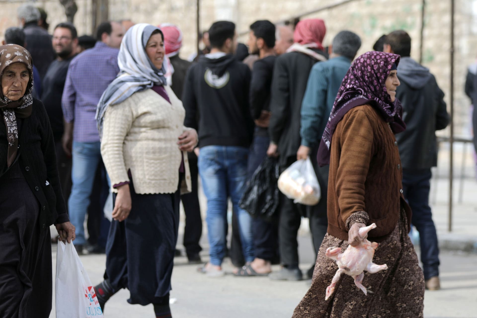 <p>Syrian women hold food aid distributed by humanitarian institutions.</p>