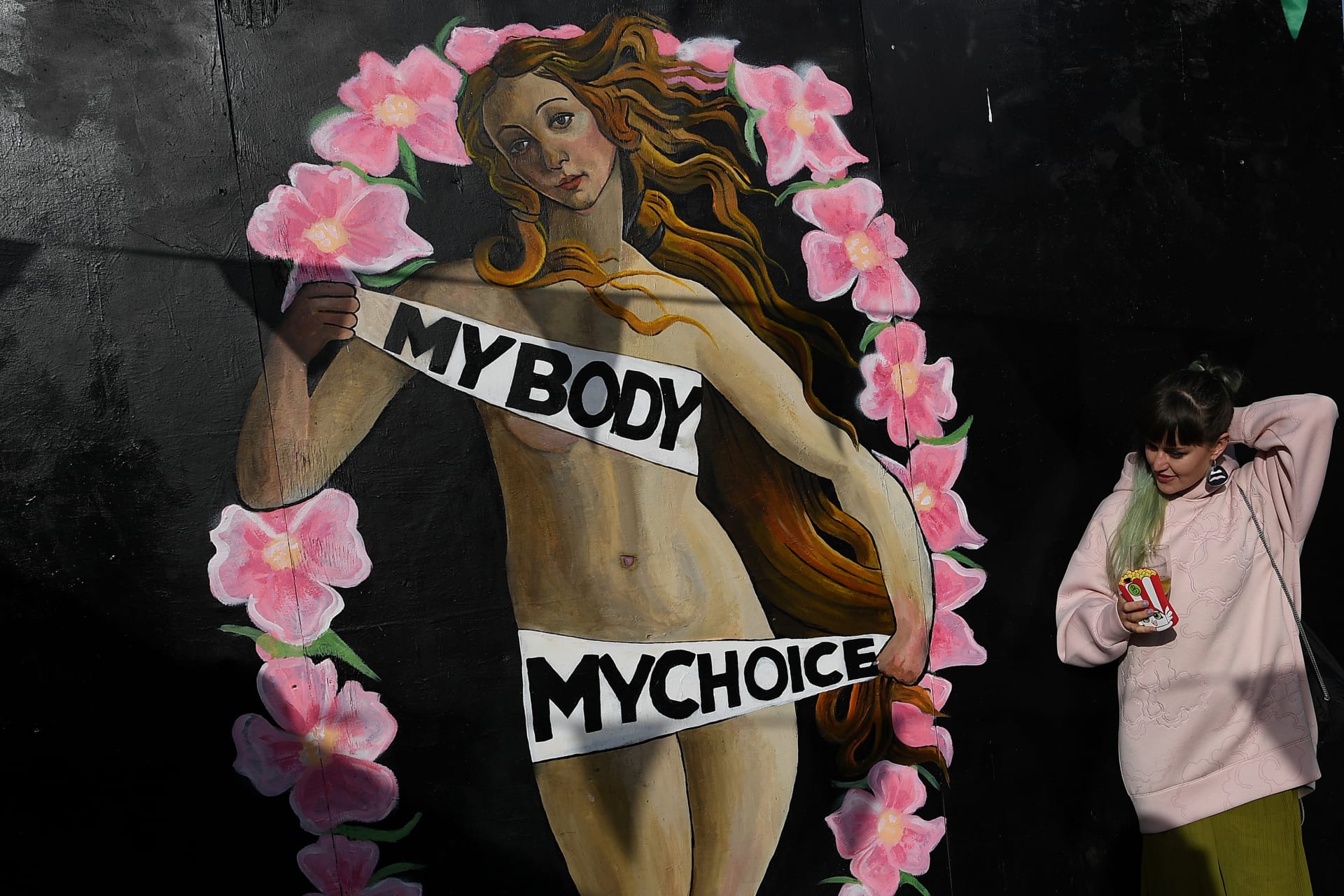 <p>A woman stands beside a pro-choice mural ahead of a May 25 referendum on abortion law, in the centre of Dublin, Ireland on May 12, 2018</p>
